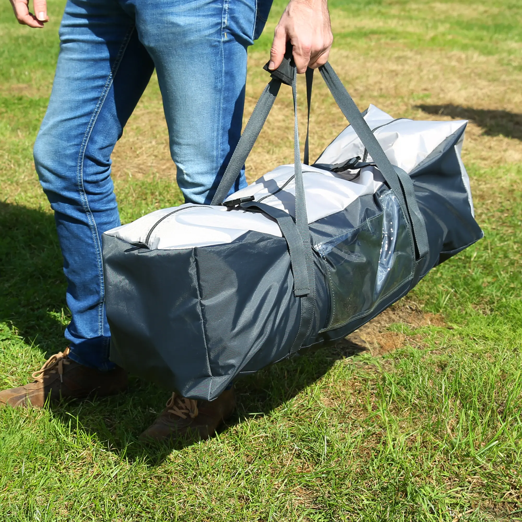 Man carrying your GEAR Amalfi Air 360 caravan sun canopy in a grey transport bag with handles, standing on grass. Ideal accessory for Hobby Beachy caravan models 360, 420, 450.