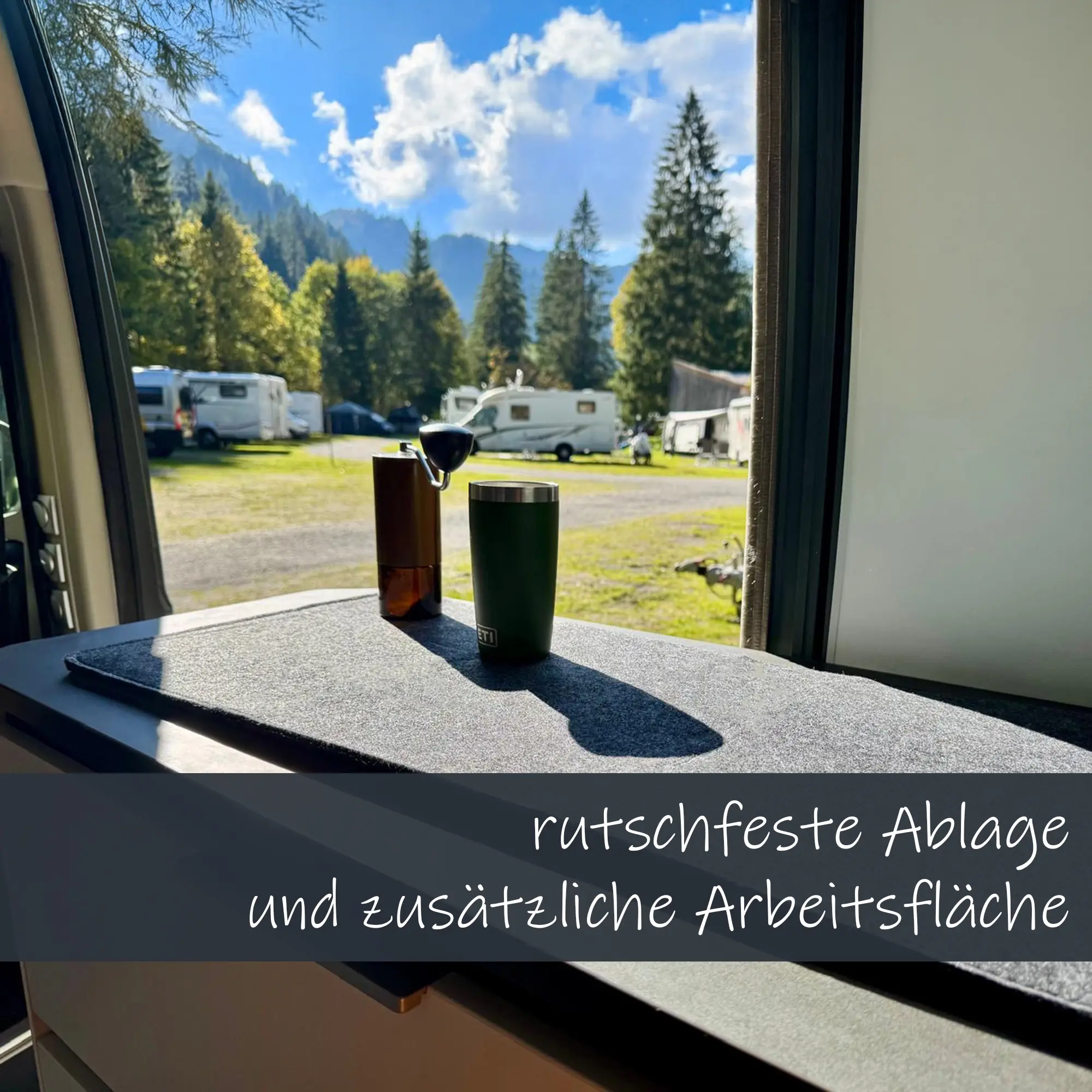 Cubierta de fieltro gris your GEAR Panaro C de 89x28 cm sobre encimera de caravana, sirve como superficie antideslizante y área de trabajo adicional; taza y molinillo encima, fondo de camping.