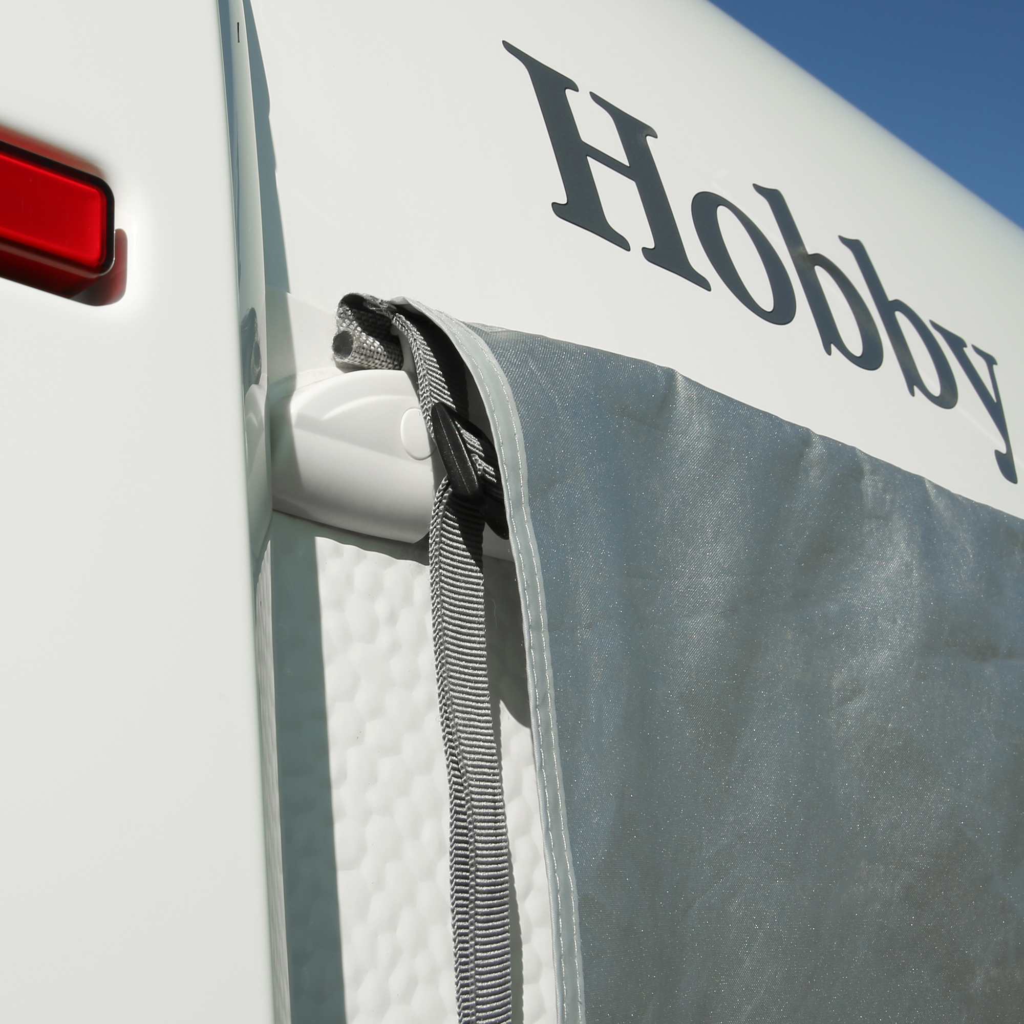 your GEAR Padua caravan window awning 140 x 70 cm with 7 mm piping, UV 80+ sun protection, shown mounted on a white caravan, featuring durable, waterproof fabric and stable aluminum construction.