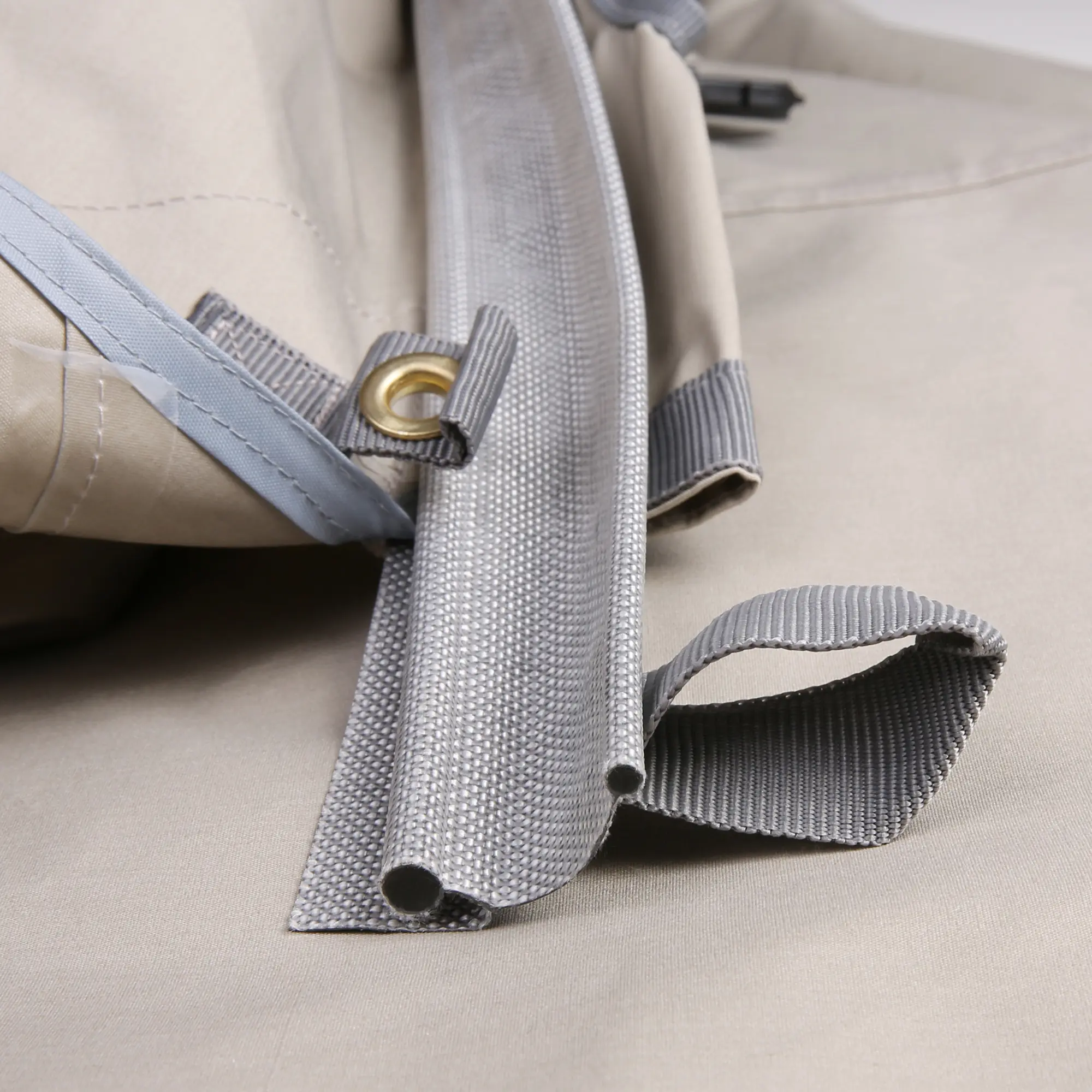 Détail du auvent your GEAR Tropea TC pour van, tissu beige avec œillet en laiton, bord renforcé et sangle grise, matériau coton résistant, protection solaire UV 50+, accessoires visibles.