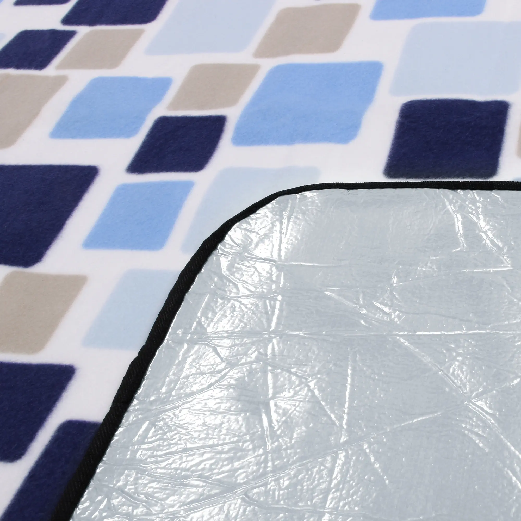 Plaid de pique-nique yourGEAR Cube XL 200x200cm, surface polaire à motifs bleus et beige, dessous en aluminium imperméable et isolant, bordure noire visible, idéal pour camping et plage.