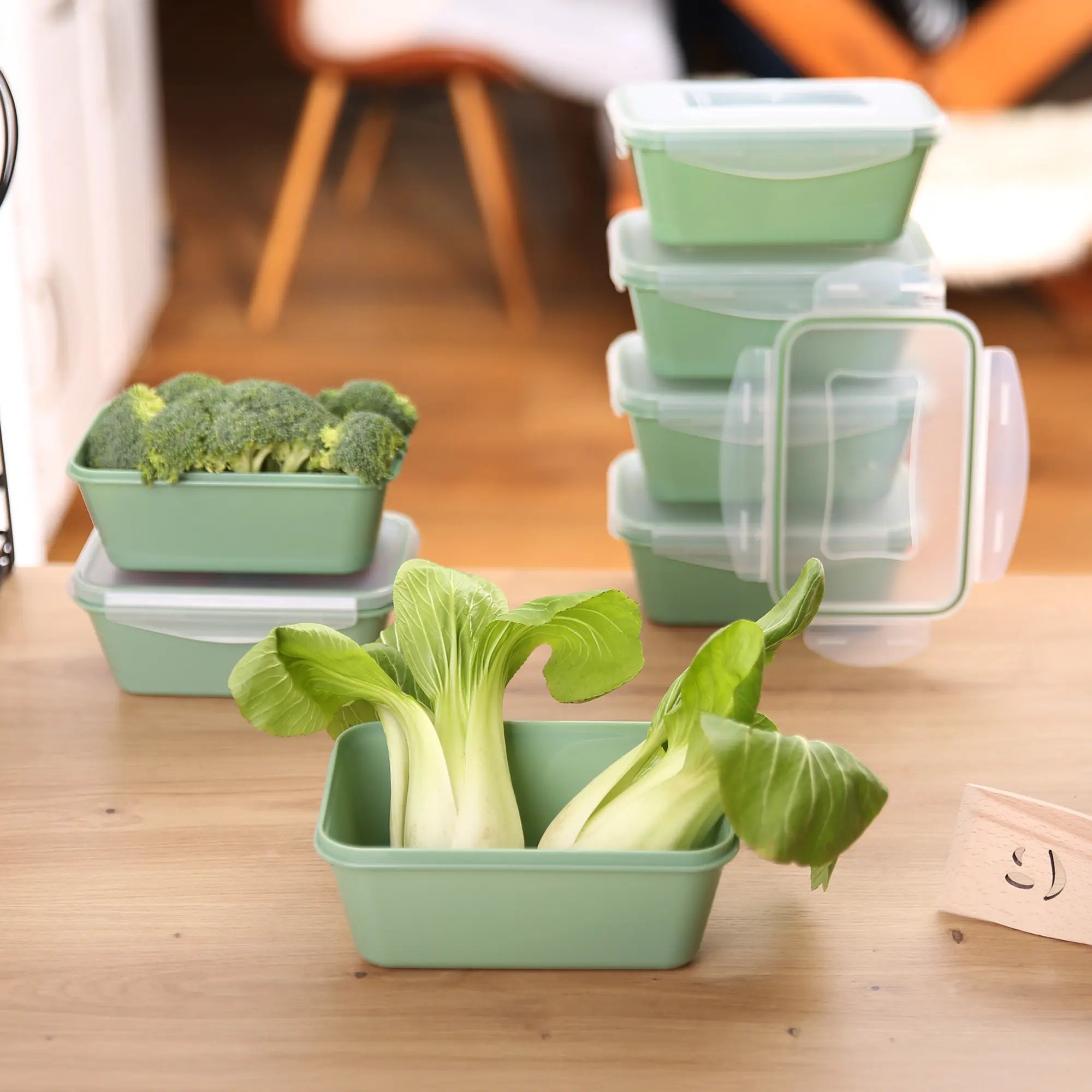 Set of six green your GEAR Pila food storage containers, each 700 ml, with transparent lids. Containers are stackable, BPA-free, shown with fresh vegetables inside, ideal for kitchen organization.