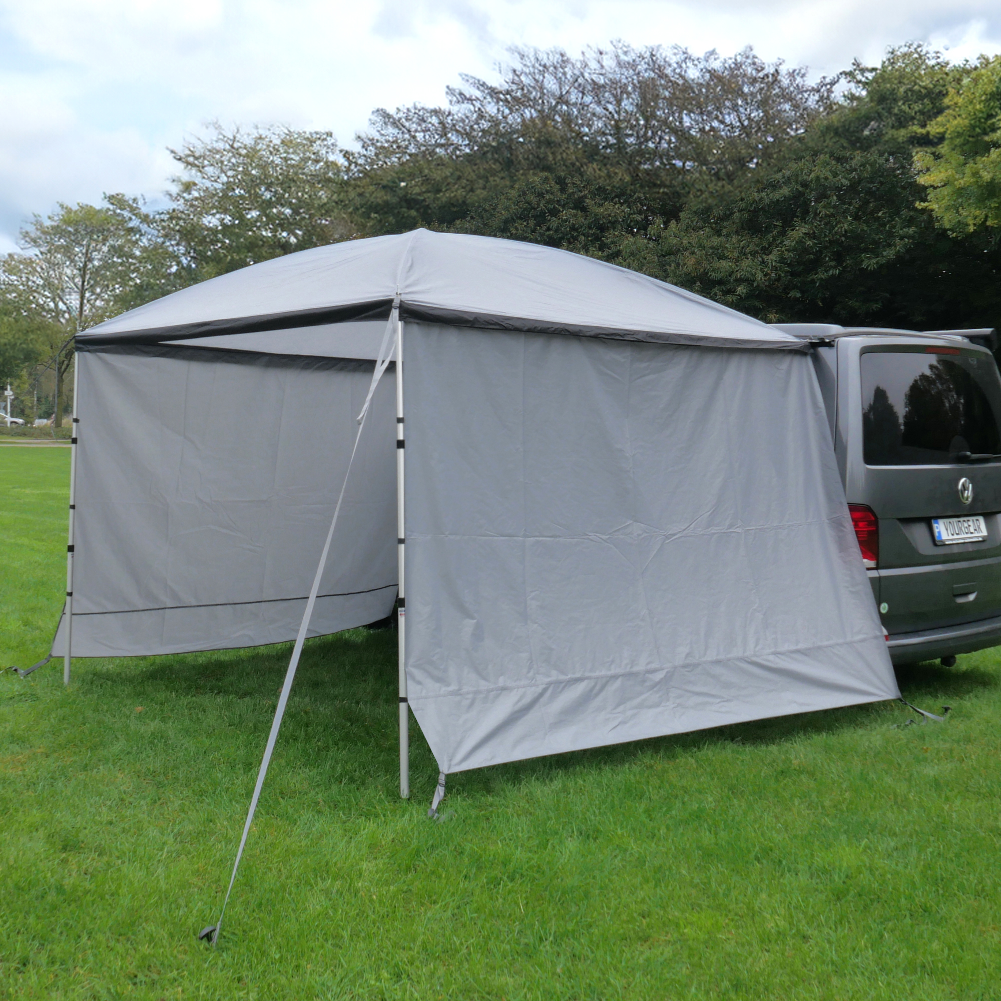 Tenda parasole your GEAR 260x260 cm con 2 pareti laterali, montata su un Volkswagen Multivan. Struttura in alluminio e telo grigio, ideale come veranda o protezione solare per camper e bus.
