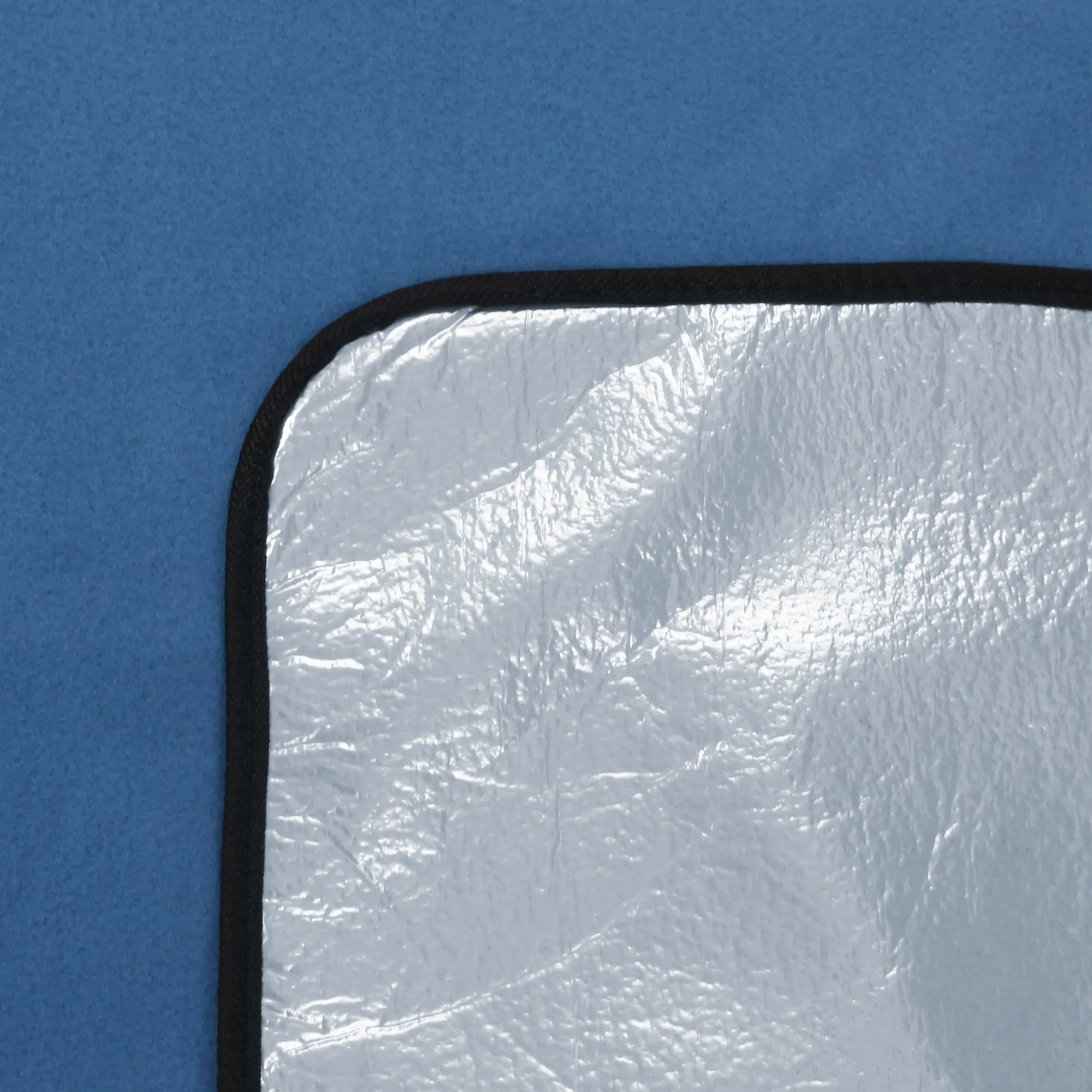 Dettaglio della coperta da picnic yourGEAR Blue XL 200x200cm, con superficie superiore in pile blu morbido e lato inferiore isolante in alluminio impermeabile, ideale per campeggio e spiaggia.