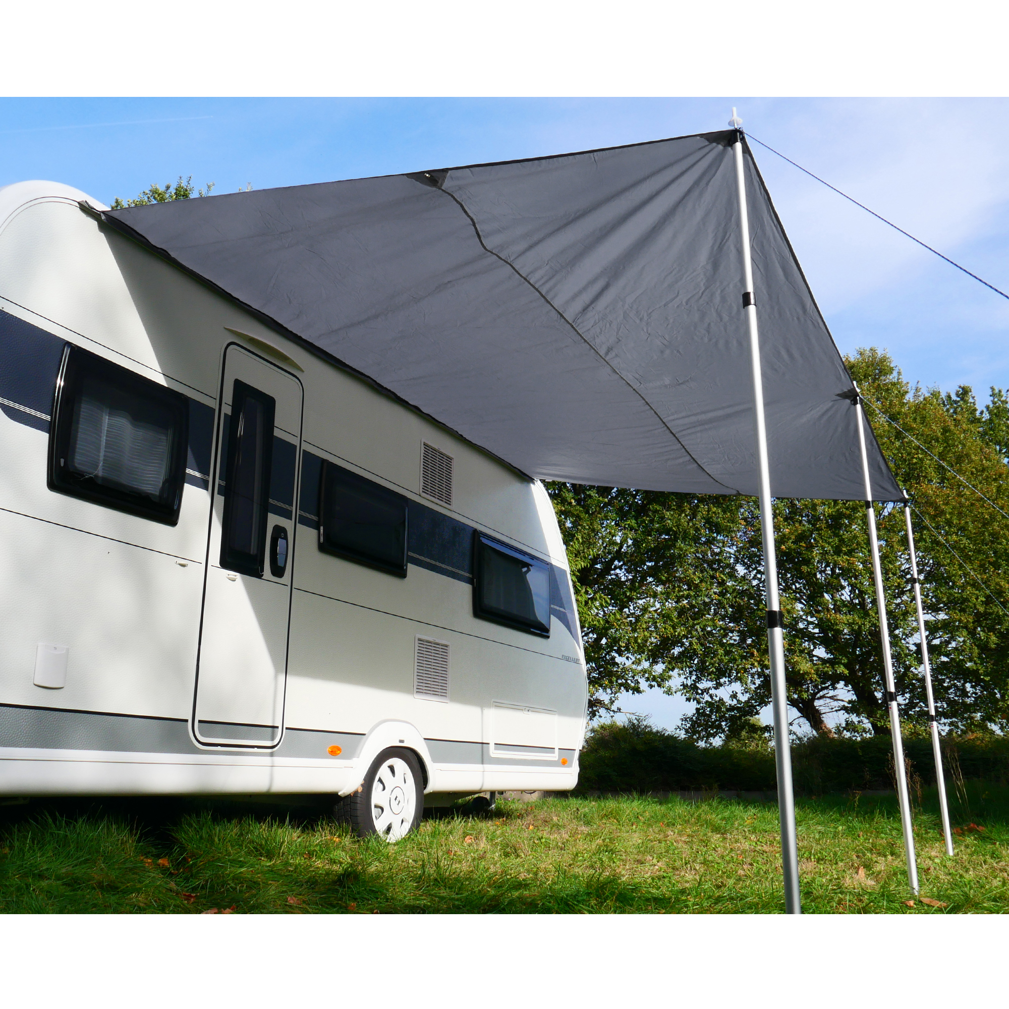 Auvent gris yourGEAR 3 x 2,4 m monté sur un camping-car, soutenu par 3 mâts en aluminium, offrant une protection solaire UV 50+ et contre la pluie, installé en plein air sur l’herbe.