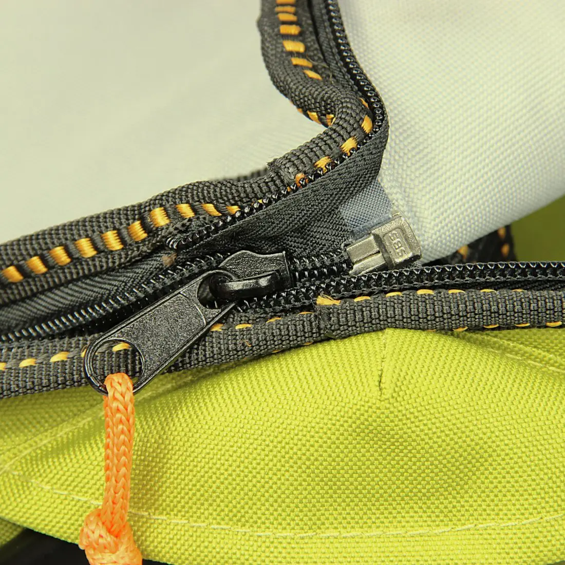 Primo piano aufreißverschluss della borsa frigo integrata del 10T Cooler Trolley Bollerwagen, con cuciture robuste gialle e tessuto resistente verde e grigio, ideale per picnic e spiaggia.