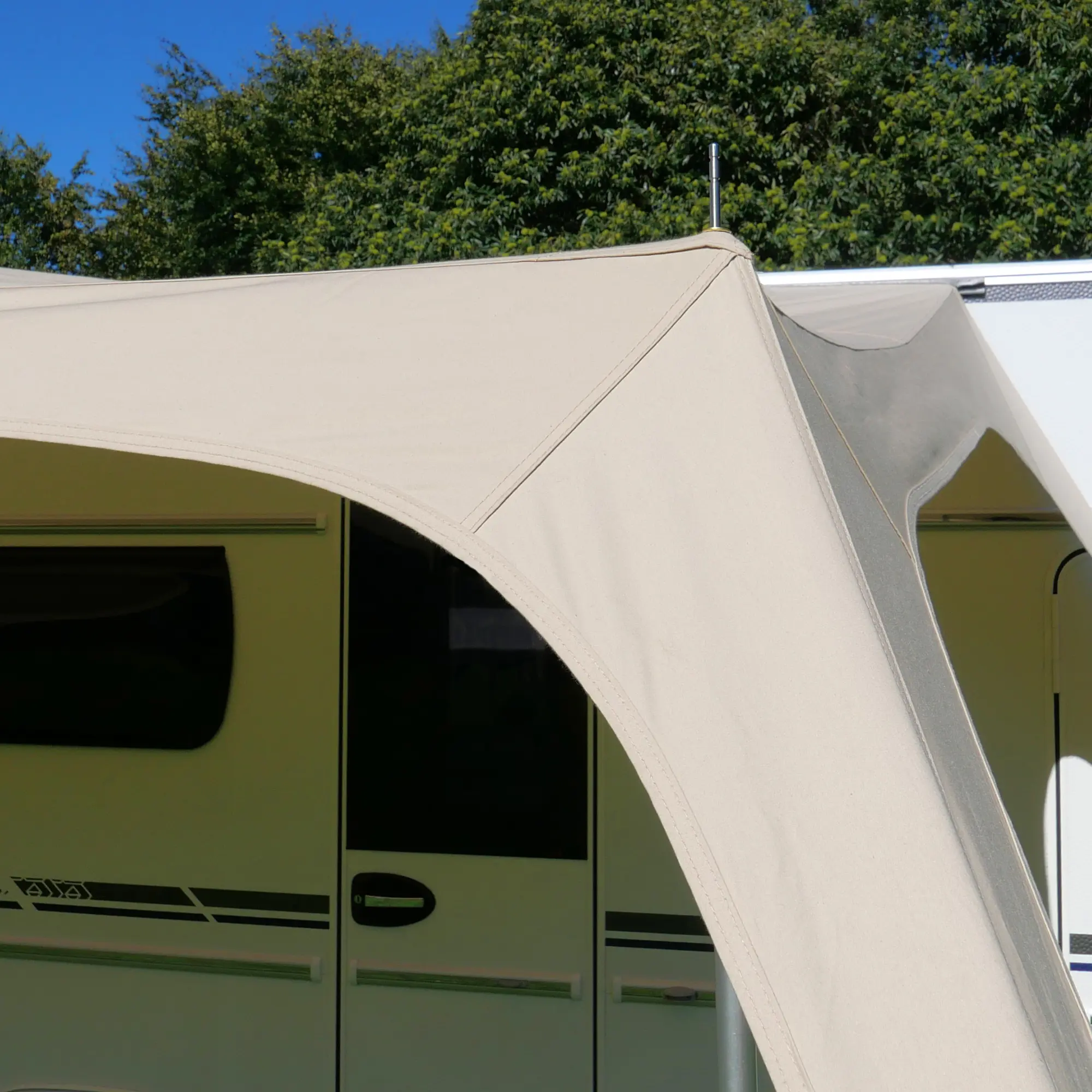Beiges your GEAR Scilla TC Caravan Tarp Sonnensegel 400x250 cm aus Baumwollmischgewebe, montiert an einem Wohnwagen, bietet UV-Schutz und Schatten, ideal als Sonnenvordach oder Wetterschutzdach beim Camping.