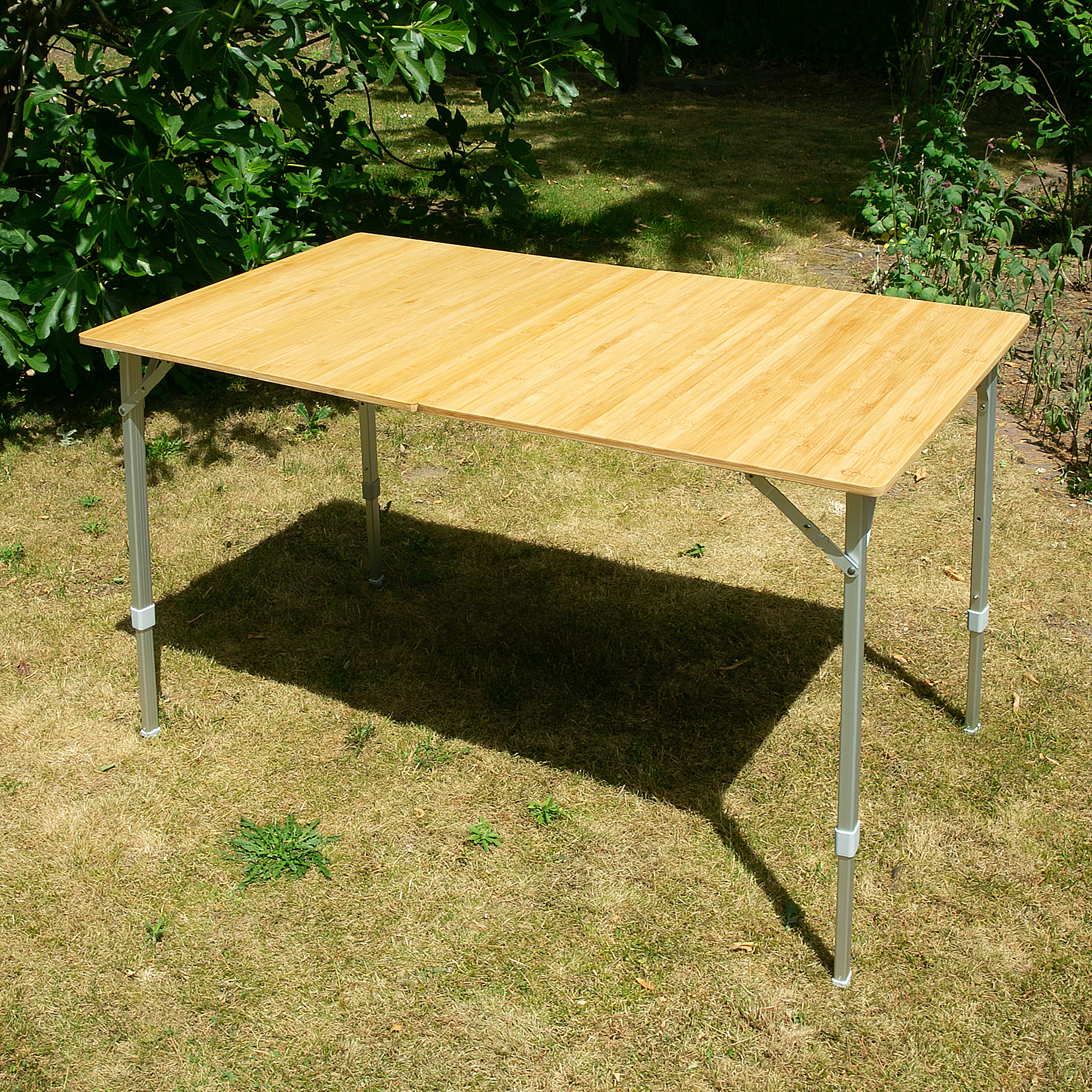 Large your GEAR Portofino XL bamboo camping table for 6 people, rectangular with a natural bamboo tabletop and silver adjustable telescopic legs, set up outdoors on grass. Ideal for camping or garden use.