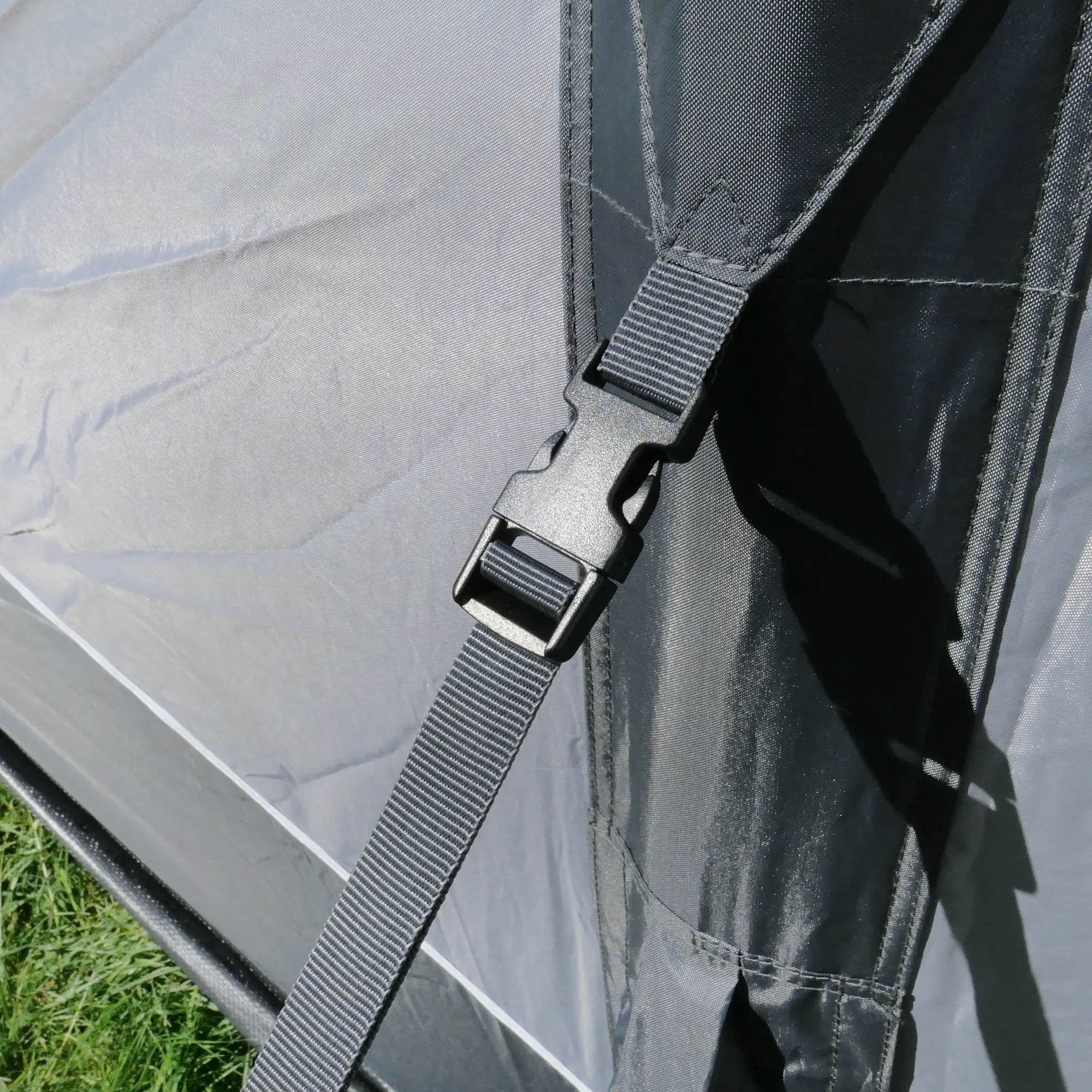 Detail view of the your GEAR Vicenza 350E AIR inflatable caravan awning, showing the sturdy black strap with adjustable buckle for secure attachment and stability of the lightweight air tent fabric.