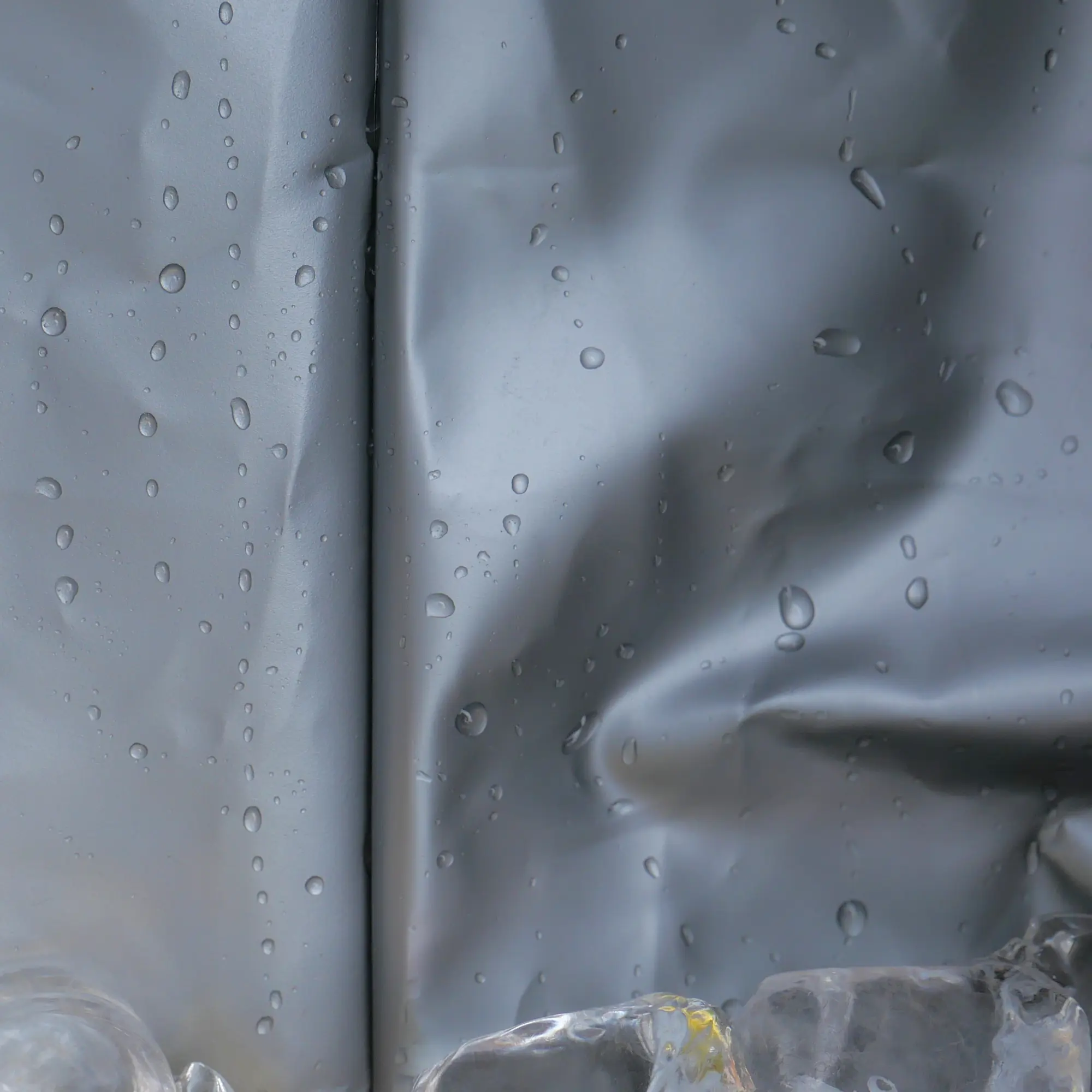 Close-up of the your GEAR Cavoli foldable cooler bag’s silver, waterproof PEVA insulation with visible water droplets and ice, highlighting the durable, easy-to-clean, and highly insulated interior material.