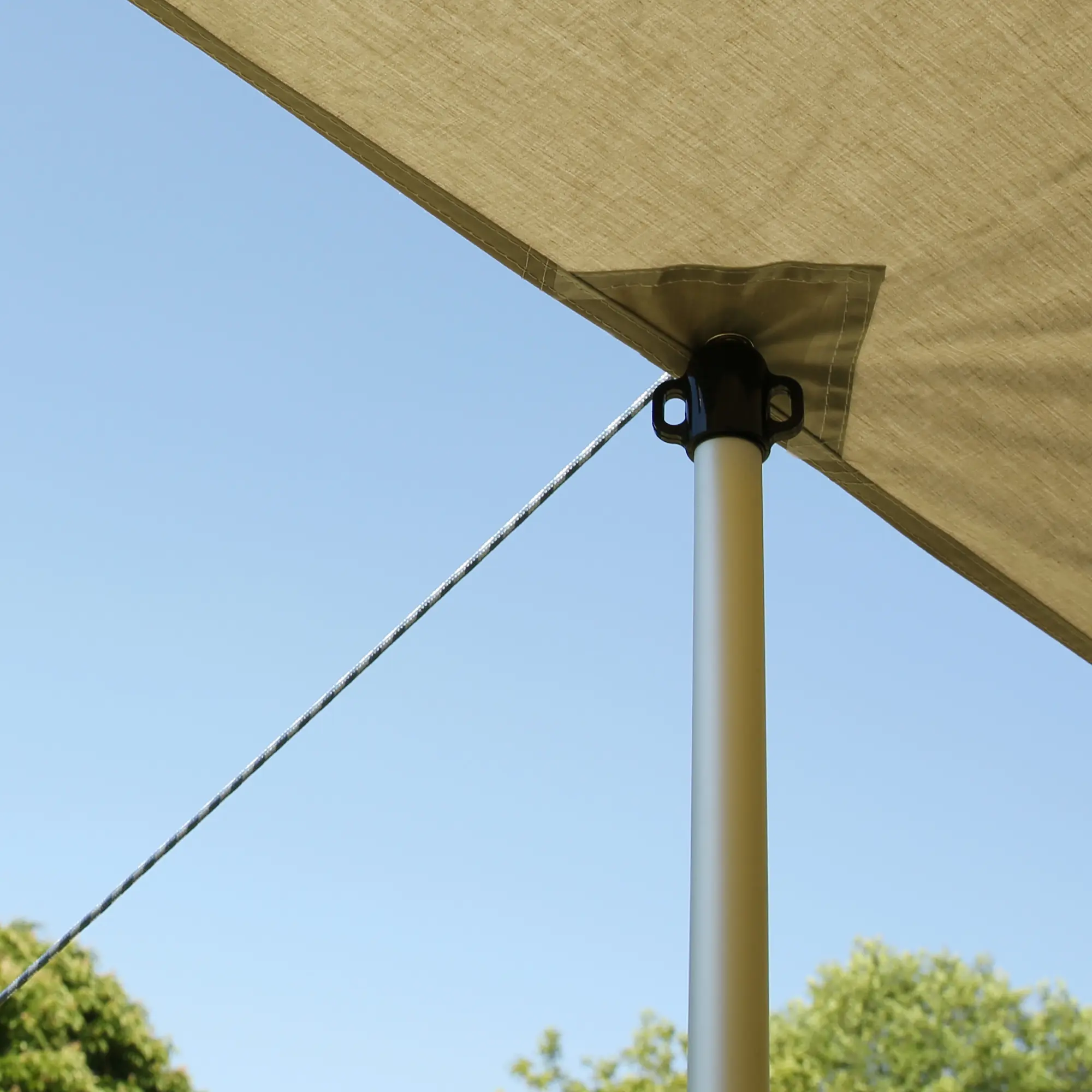 Auvent your GEAR pour caravane, toile beige en mélange de coton, fixé sur mât télescopique en aluminium avec corde de tension, protection solaire et ombrage en extérieur sous ciel bleu.