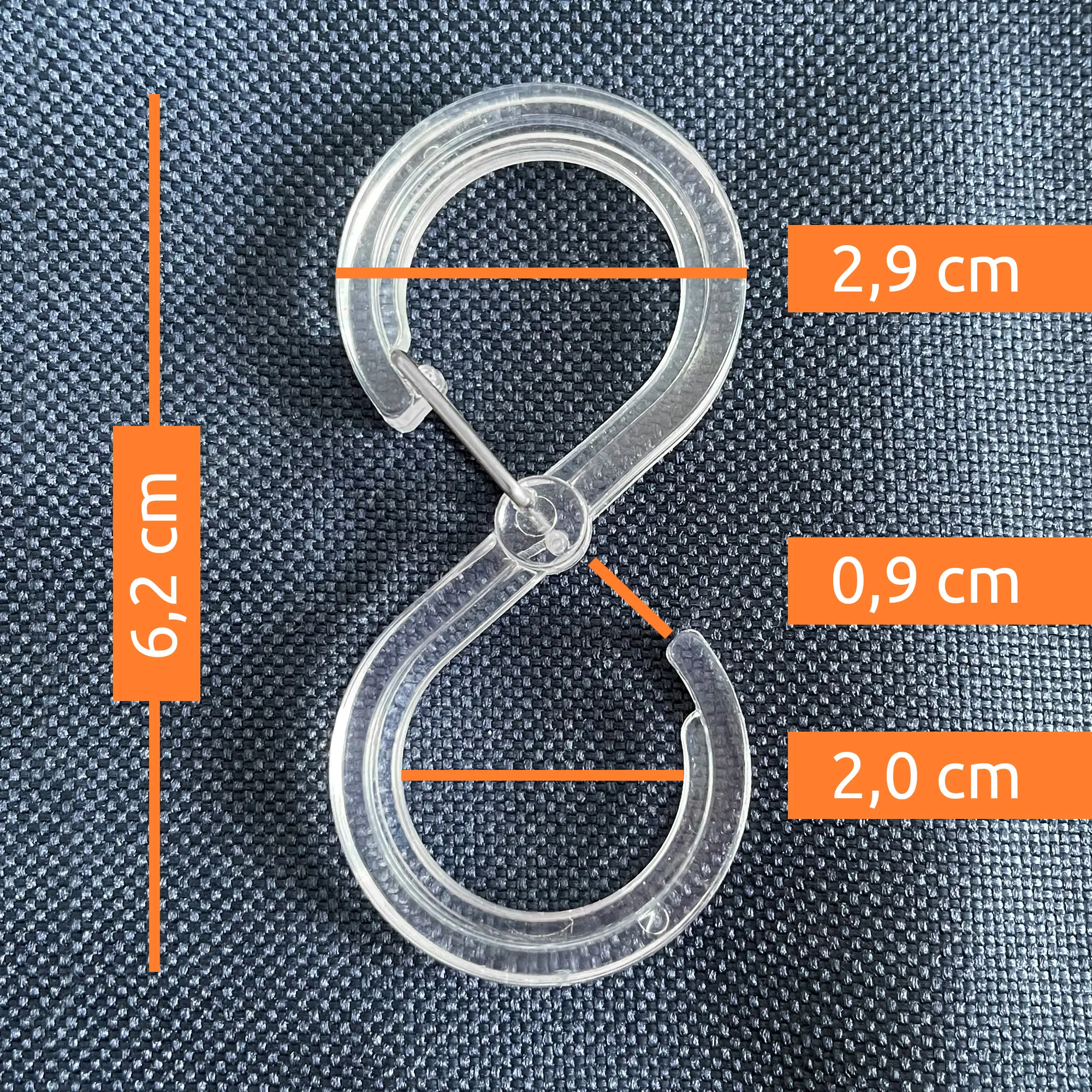 Transparent S-hook for your GEAR Caravan Organizer, 6.2 cm long with 2.9 cm and 2.0 cm diameter openings, shown on a dark textile background with orange measurement labels. Ideal for tents, awnings, and caravans.