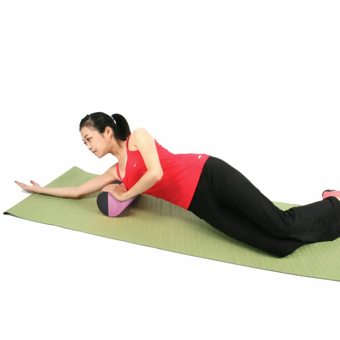 Mujer usando un rodillo de espuma Carnegie EVA Pilates de 90x15 cm para masaje y ejercicios de fascia sobre una esterilla verde, ideal para yoga, pilates y entrenamiento de fitness.