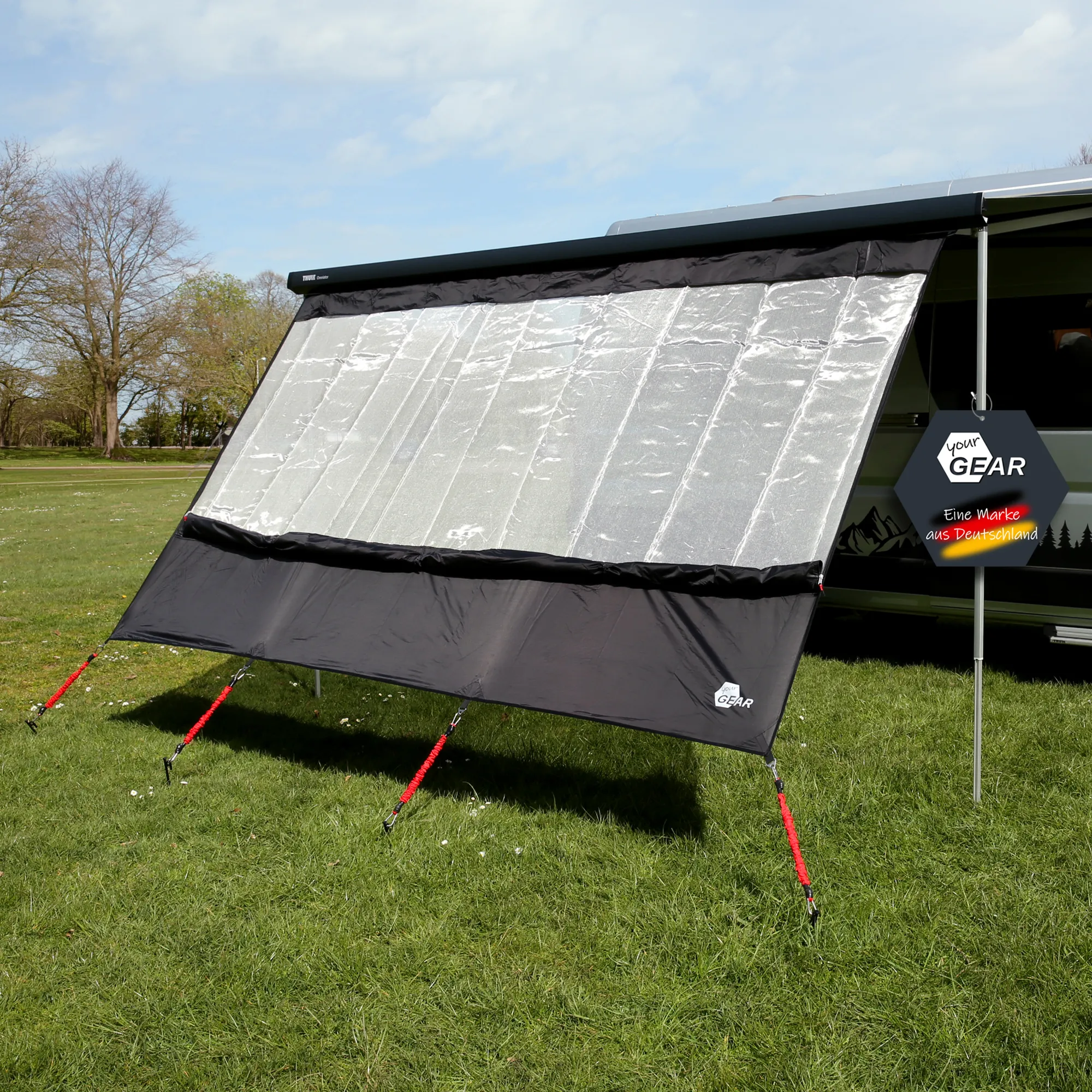 your GEAR Phoenix Sun & Rain 240x200cm awning front panel with silver-black reflective mesh upper, black lower cover, red tension straps and metal pegs shown attached to camper awning on grass