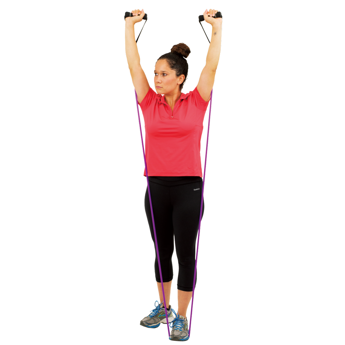 Frau benutzt das Spirit Expander Medium Fitnessband (13,5 kg Zugkraft) mit Griffen, steht auf dem violetten Gymnastikband und hebt die Arme nach oben, geeignet für Kraft- und Ausdauertraining.