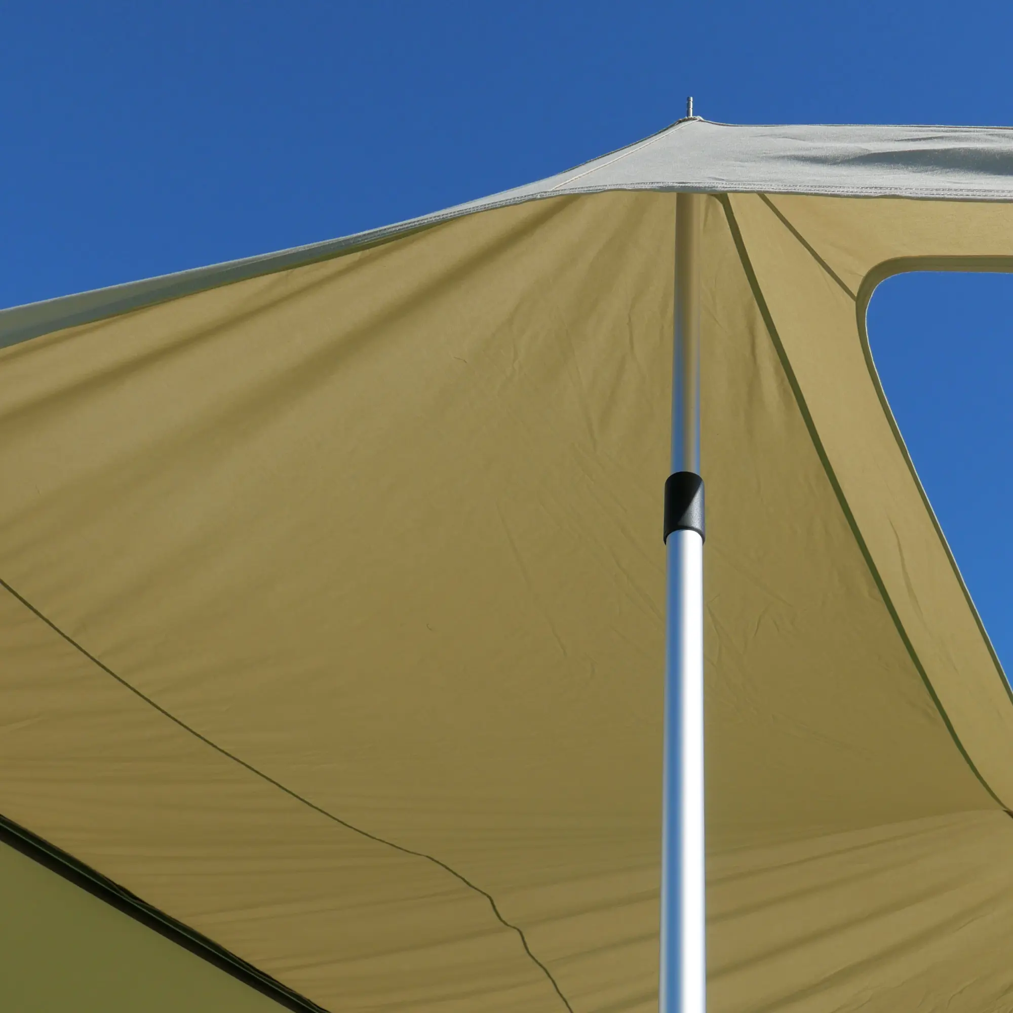 Beiges your GEAR Scilla TC Caravan Sonnensegel 400x250 cm mit Aluminium-Stützstange, atmungsaktivem Baumwollmischgewebe, aufgespannt unter blauem Himmel, ideal als Sonnenvordach für Wohnwagen und Wohnmobile.