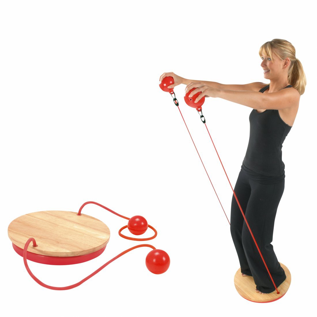 Frau trainiert auf dem Carnegie Balance Board mit zwei roten Gewichtsbällen und Widerstandsband; das Balance Board aus Holz, Bälle und Band sind für vielseitiges Fitness- und Rehatraining geeignet.