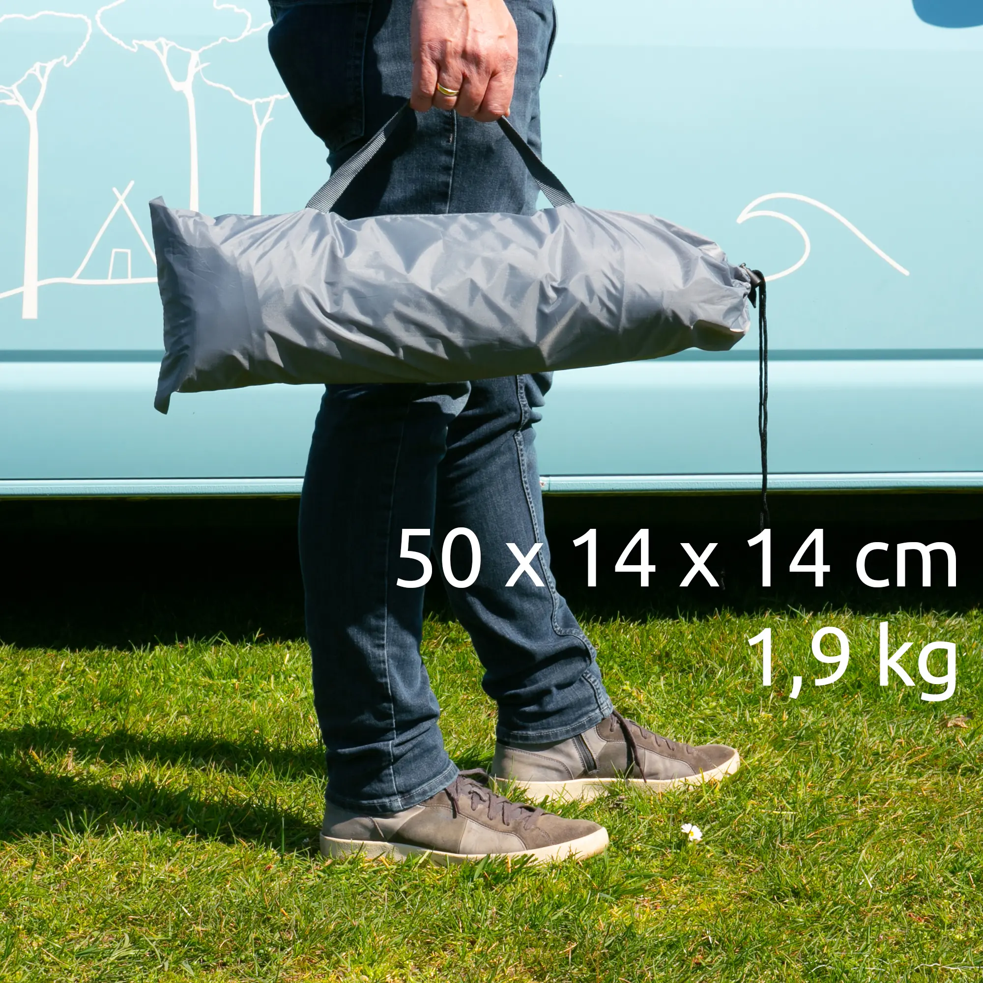 Homme tenant un sac de transport gris contenant deux parois latérales your GEAR Sun + Rain Blocker pour auvent de camping-car, dimensions 50 x 14 x 14 cm, poids 1,9 kg, devant un van bleu.