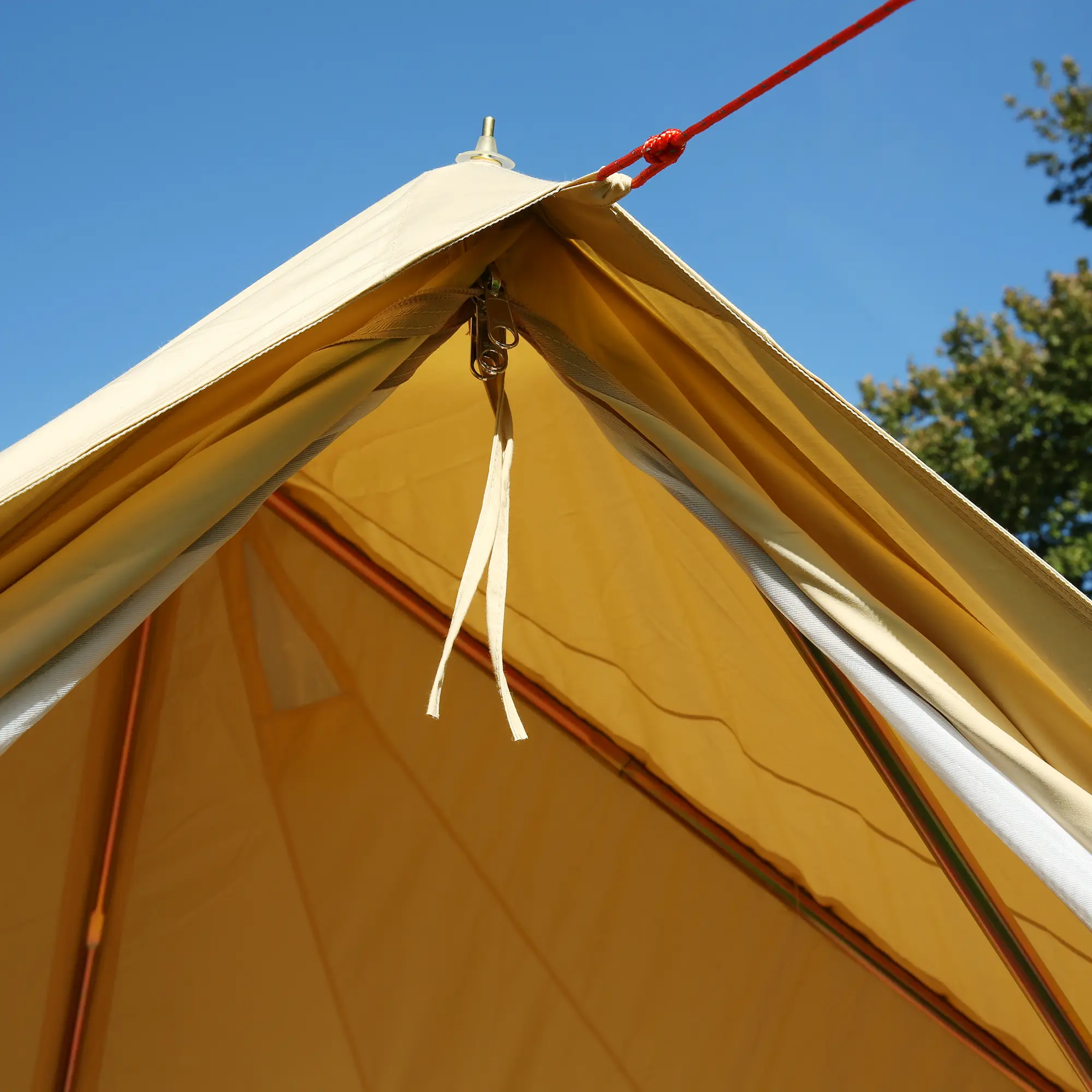 Close-up of the your GEAR Gobi 3 tipi tent entrance showing the A-frame structure, durable cotton-blend fabric, and UV50+ protection, with visible guy rope and blue sky in the background.