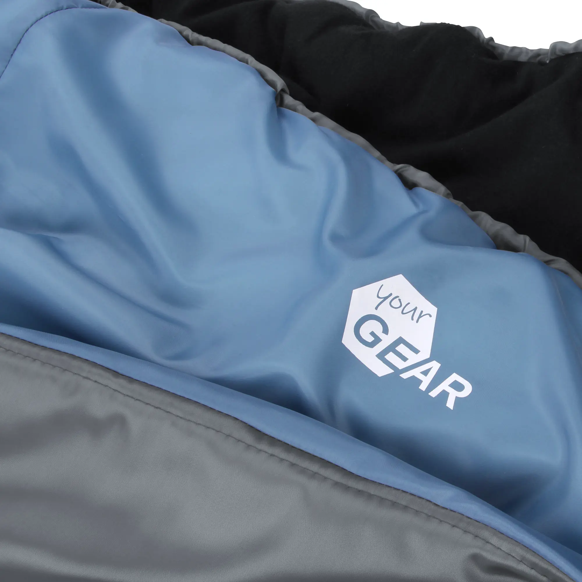 yourGEAR XXL Schlafsack Sumatra in Blau und Grau, detailreiche Nahaufnahme des Außenmaterials mit Logo, sichtbar wattierte und weiche Oberfläche, für 3-4 Jahreszeiten geeignet.
