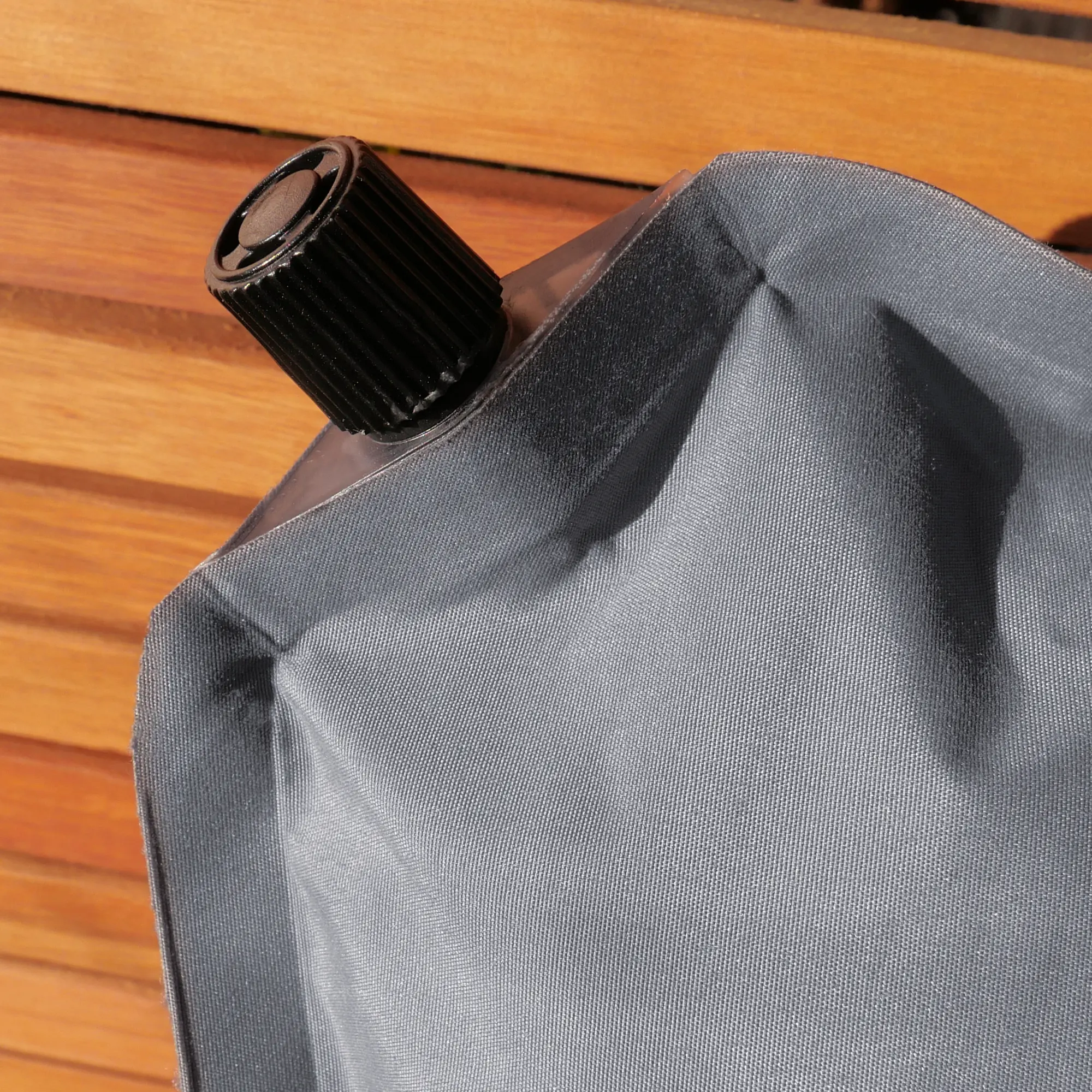 Cojín de viaje yourGEAR autoinflable gris con válvula de inflado negra, tejido resistente, ideal para camping y viajeros, tamaño compacto y relleno de espuma comprimible, mostrado en superficie de madera.