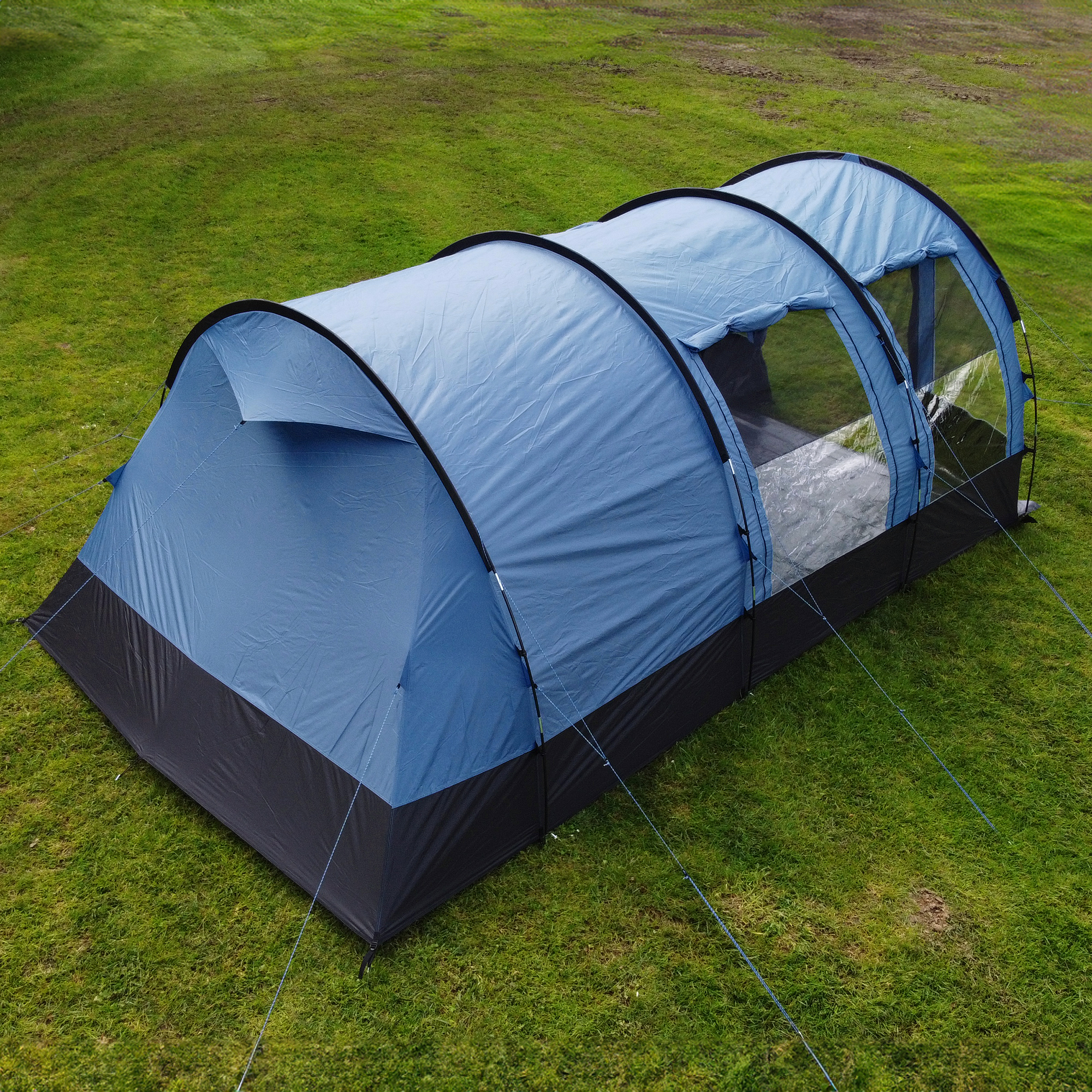 Tente tunnel your GEAR Mistral pour 6 personnes, coloris bleu et noir, grandes fenêtres transparentes latérales, structure spacieuse et haute, adaptée au camping familial, installée sur pelouse verte.