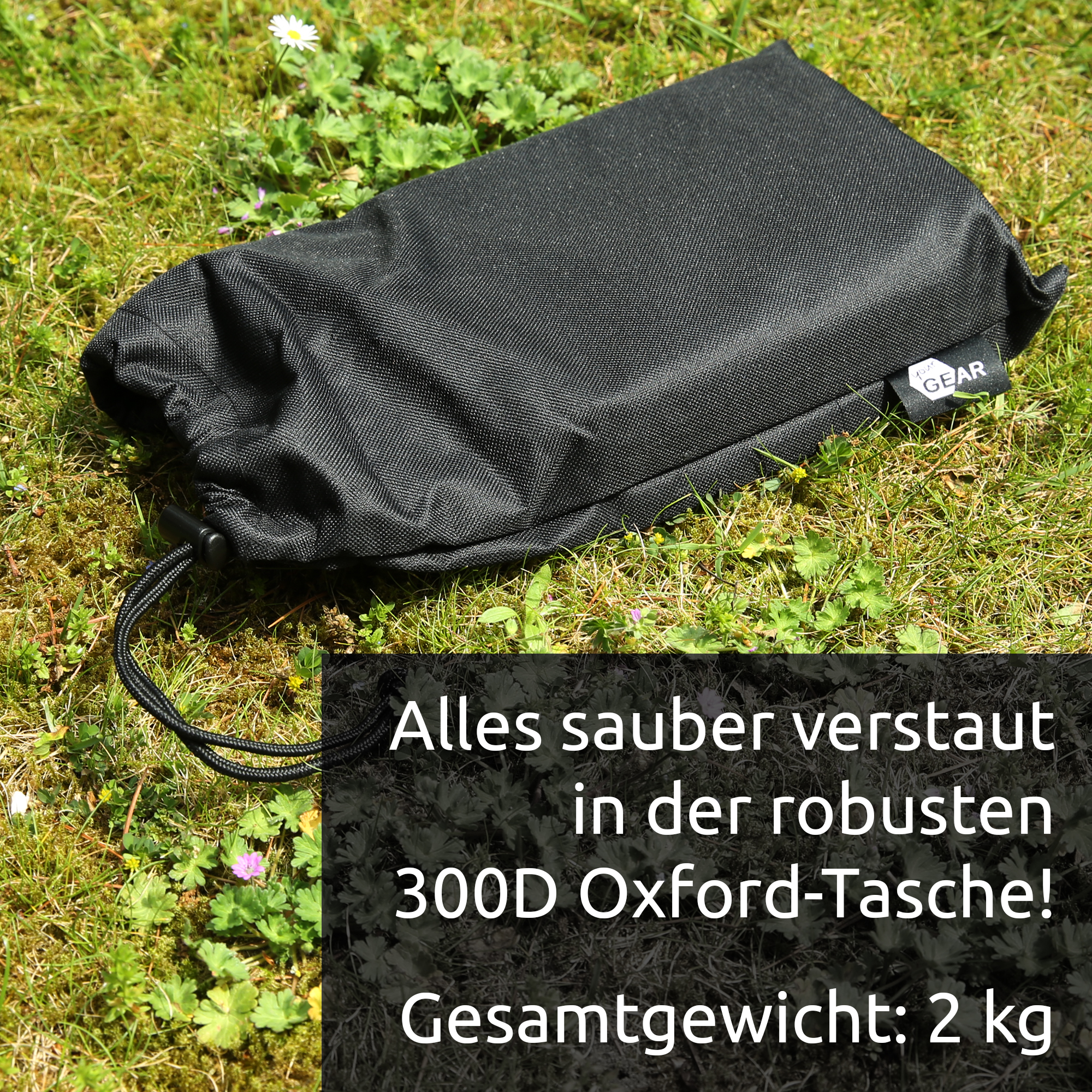 Black textured 300D Oxford storage pouch with drawstring and small your GEAR tag, shown on grass — protective carrying bag for Montana anchor plate set for awning feet.