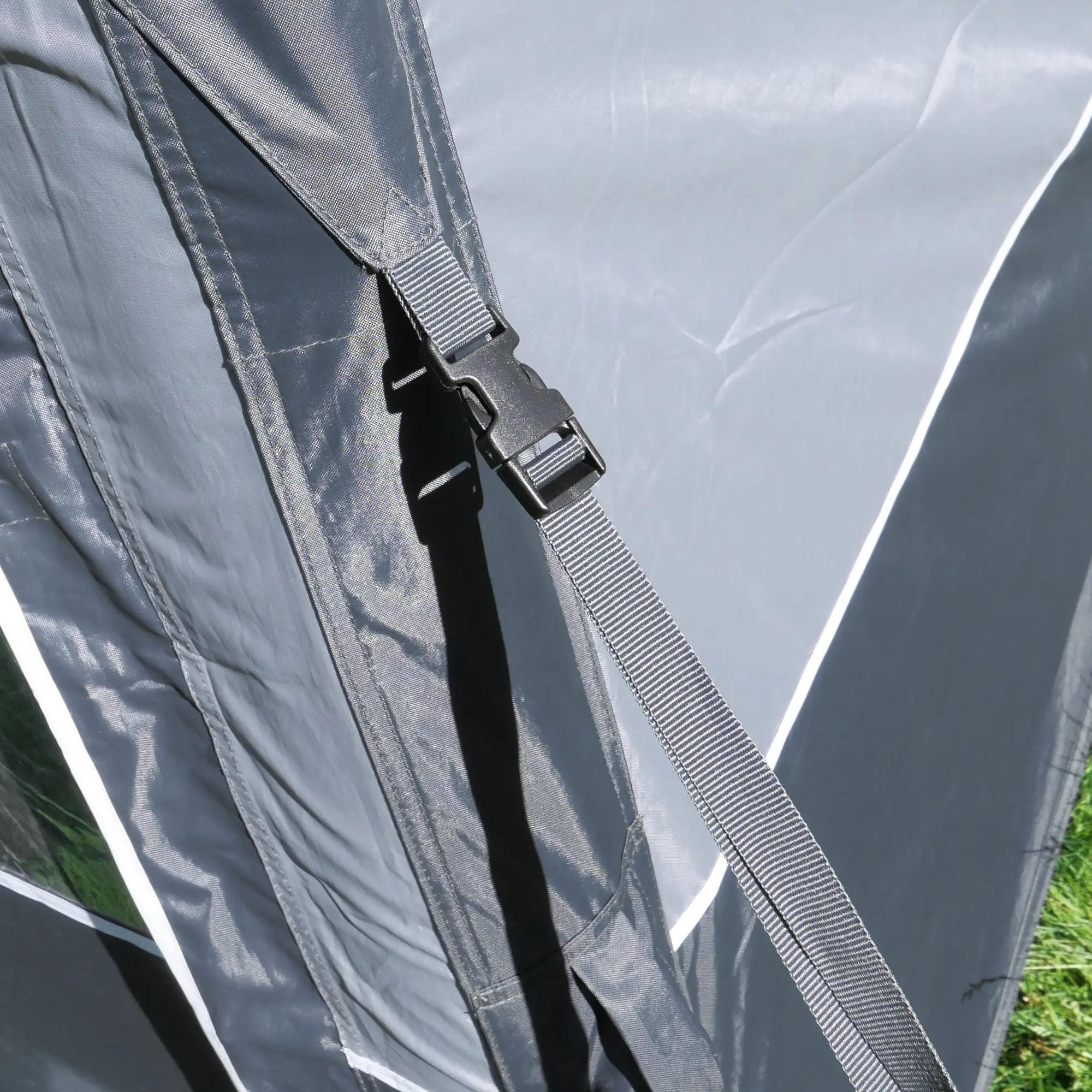 Detailaufnahme des your GEAR Otranto Air aufblasbaren Sonnenvordachs: Robustes, graues Polyestergewebe mit stabiler Gurtbefestigung und Klickverschluss, geeignet für Wohnwagen und Wohnmobile, wetterfest und strapazierfähig.