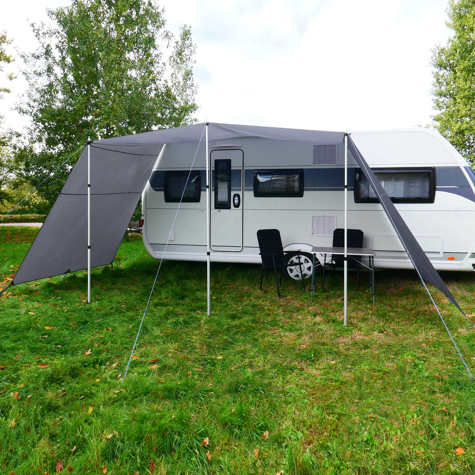 Toldo para caravana your GEAR Teramo 300 gris con paredes laterales, postes telescópicos de aluminio, instalado junto a un remolque sobre césped; proporciona sombra y protección UV 50+.