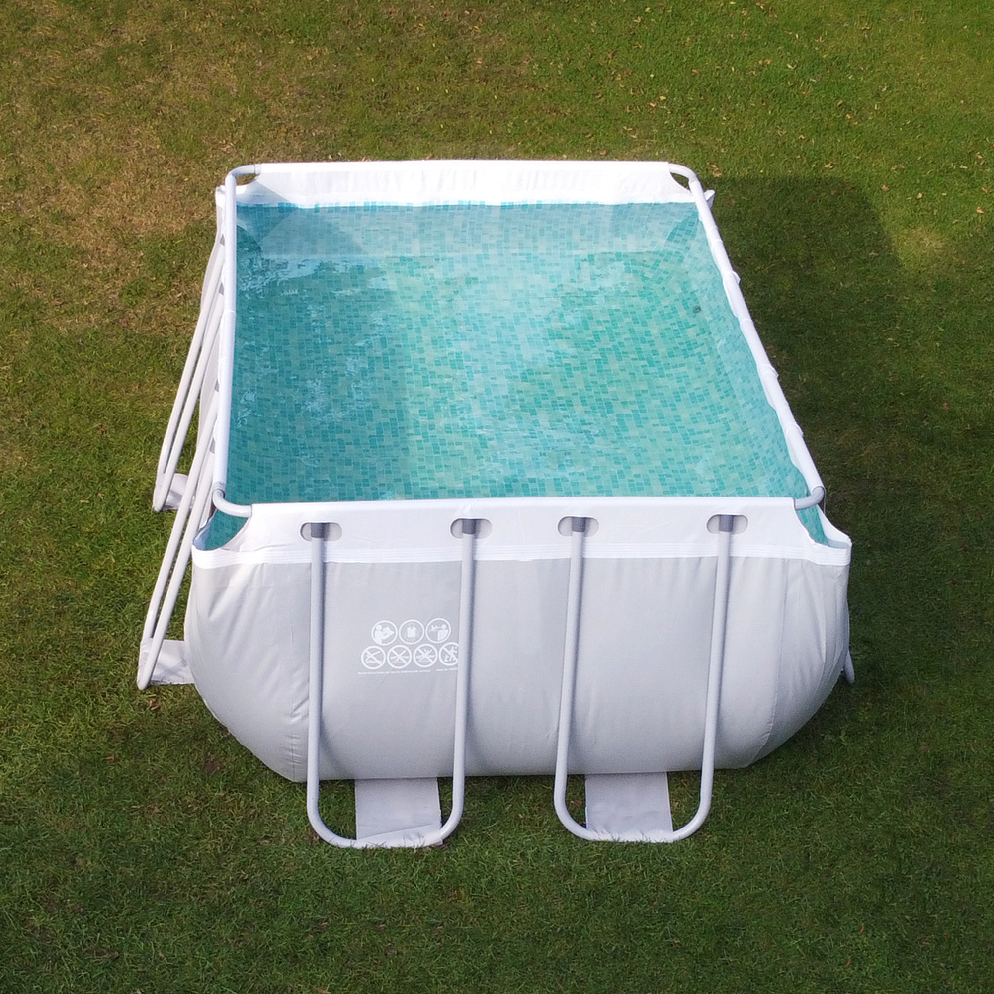 Piscine familiale your GEAR 3x2x1m à cadre en acier, extérieur gris et blanc, intérieur à motif mosaïque bleu, installée sur pelouse, idéale pour jardin ou terrasse, structure robuste et spacieuse.
