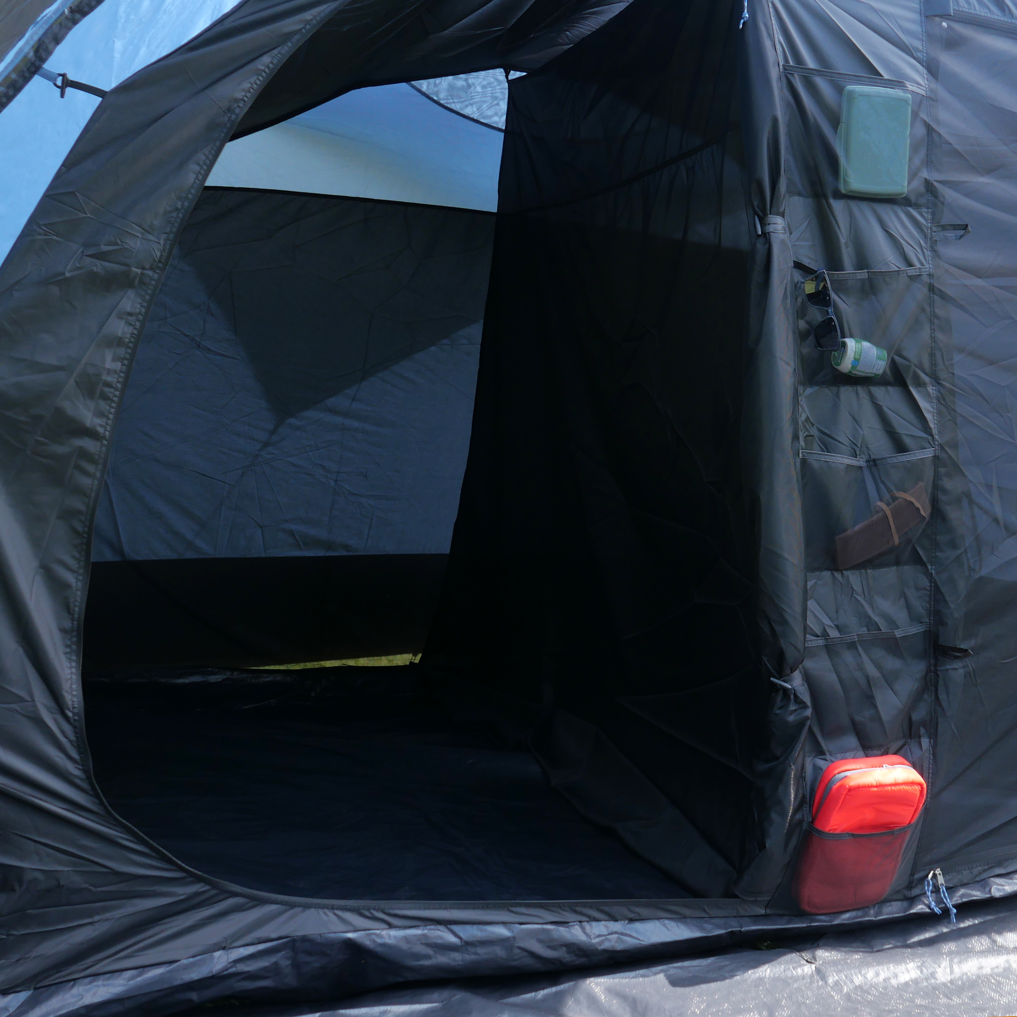 Intérieur du your GEAR Zelt Mistral, tente tunnel familiale pour 6 personnes, avec grande cabine de couchage, poches de rangement sur le côté et espace spacieux; tissu foncé, entrée large, sol imperméable.