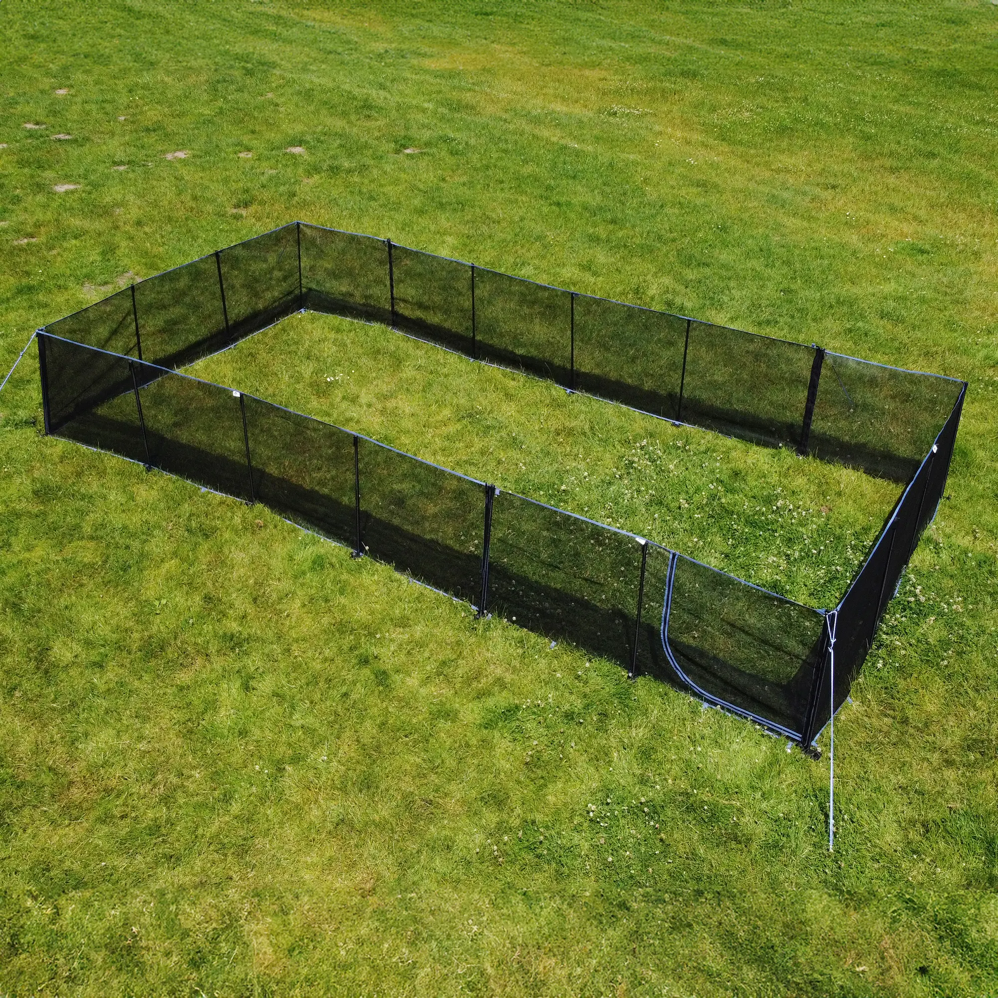 Enclos pour chien your GEAR Larino 400, hauteur 90 cm, structure rectangulaire noire, éléments modulaires reliés par fermetures éclair, installé sur pelouse, idéal pour camping ou jardin, extensible à l’infini.