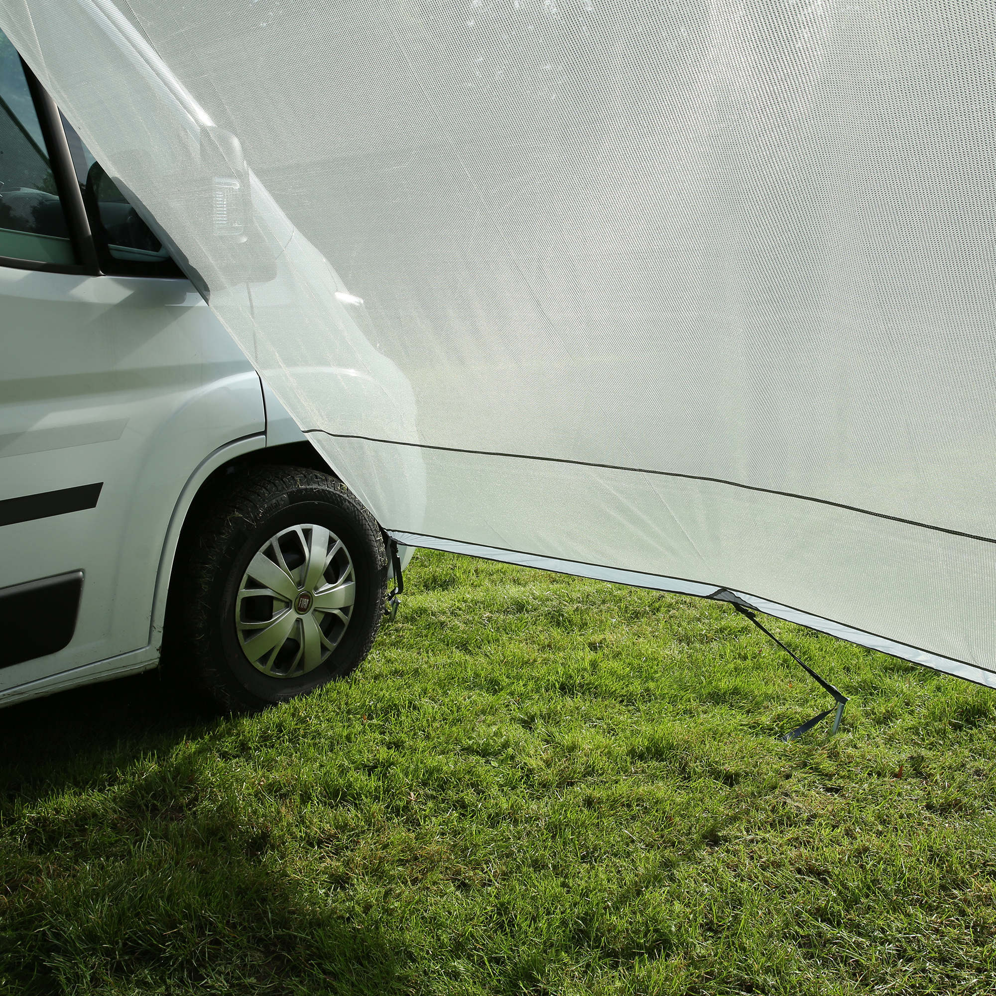 Wind-permeable your GEAR Capri Side Blocker attached to a camper van awning, providing sun and privacy protection; visible mesh fabric and mounting poles, ideal for Thule, Fiamma, or Dometic awnings.