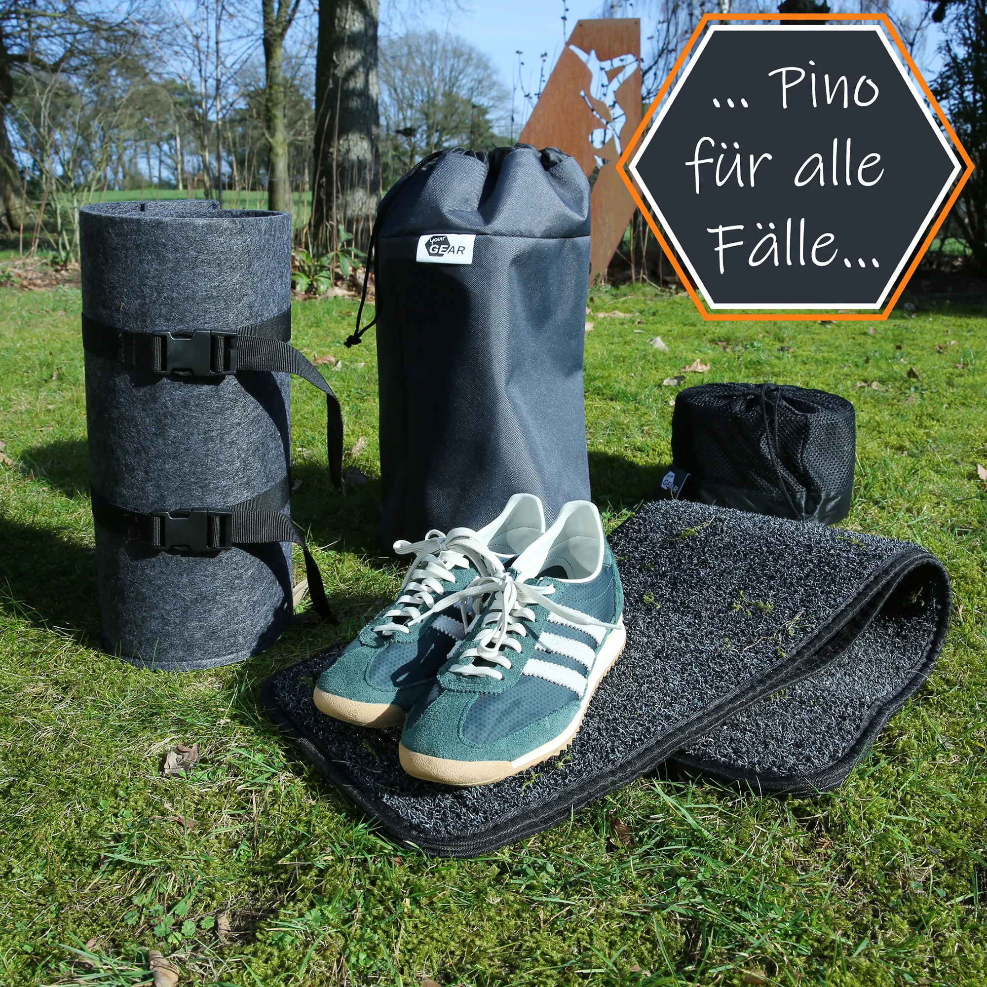 Chaussures de sport vertes posées sur tapis d'extérieur noir, entourées de sacs et rouleaux de rangement sur pelouse, pancarte hexagonale «… Pino für alle Fälle… » à droite.
