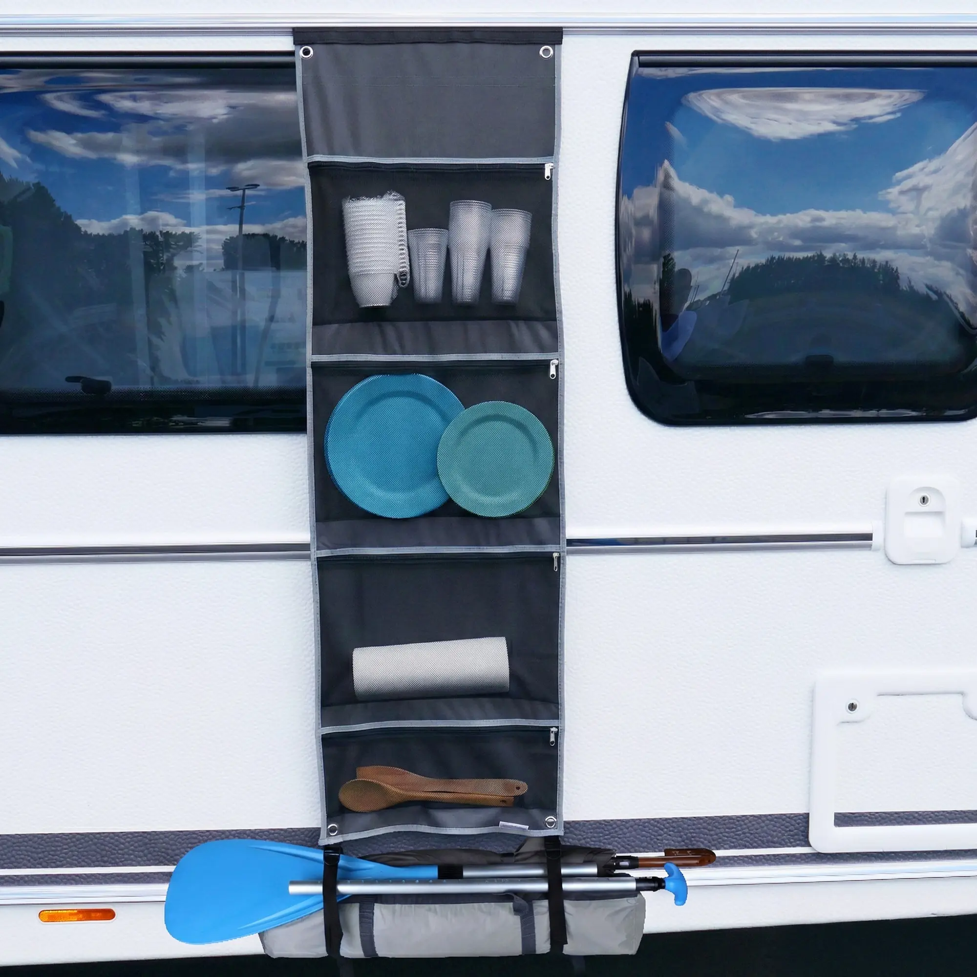 Organiseur suspendu your GEAR gris en mesh 4 compartiments (140x45 cm) fixé sur caravane, poches zippées et en filet contenant gobelets, assiettes, torchon et ustensiles, œillets et bandes pour fixation par keder ou crochets