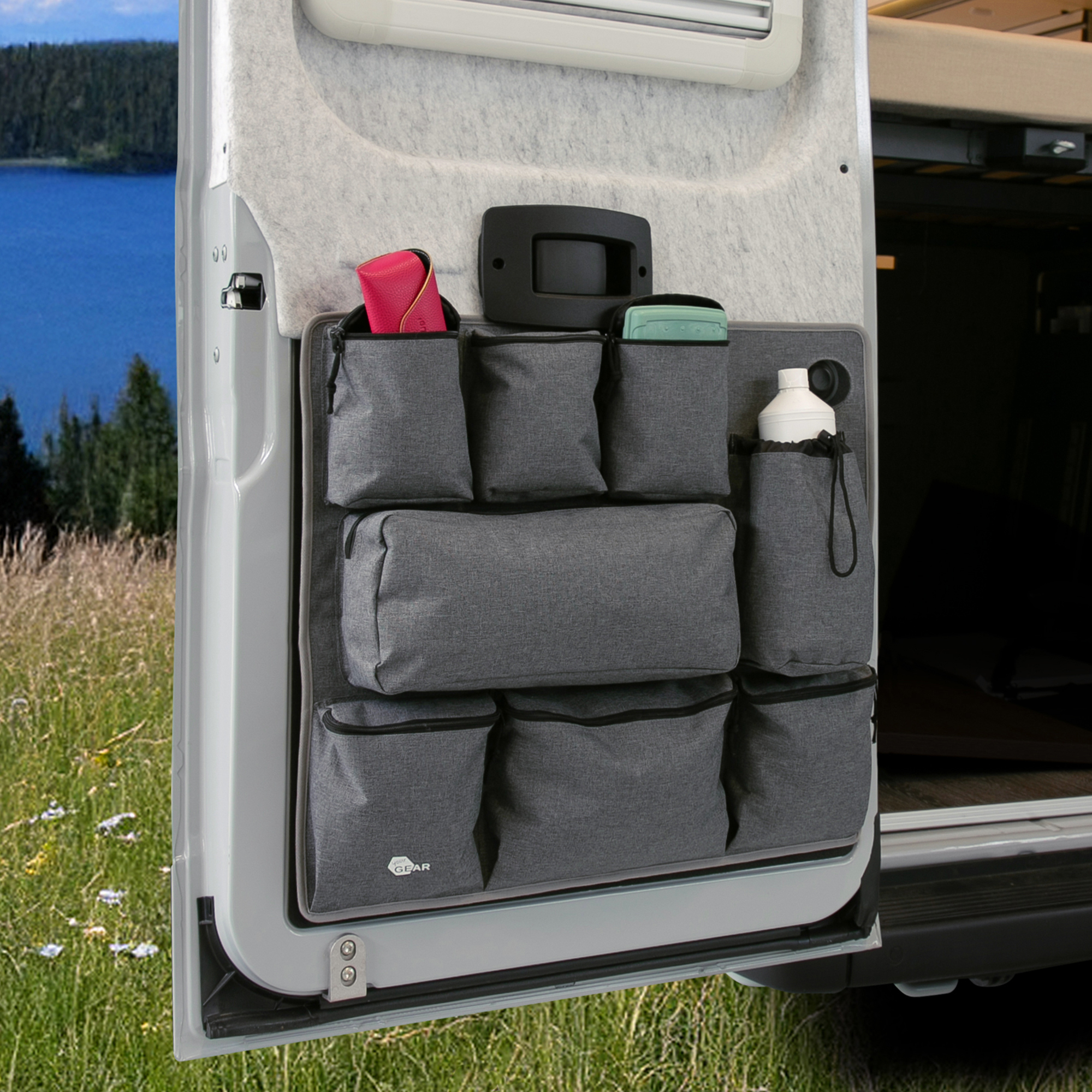 Organisateur your GEAR Ortles L gris fixé sur la porte arrière gauche d’un camping-car, doté de 8 poches robustes de différentes tailles pour optimiser le rangement d’accessoires et d’objets de voyage.