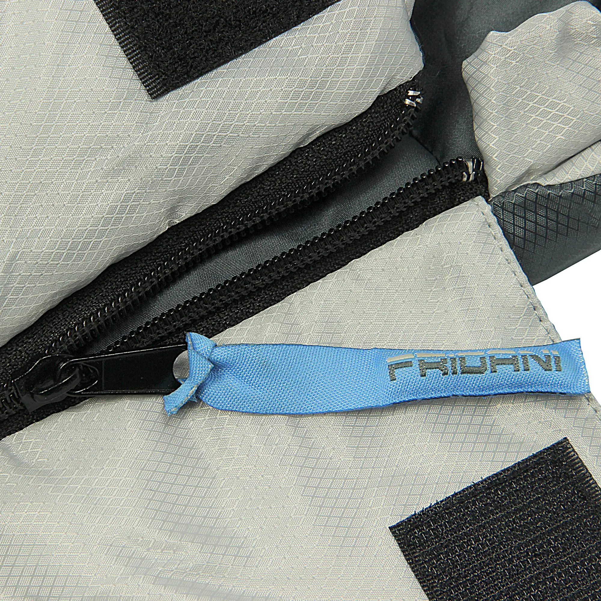 Primo piano di una cerniera nera su tessuto grigio con una linguetta blu e la scritta "FRIDANI".