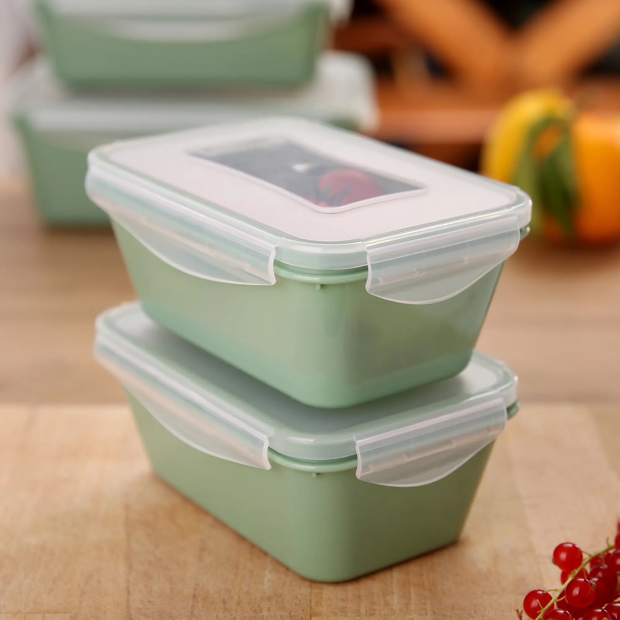 Zwei grüne your GEAR Pila Frischhaltedosen à 1000 ml mit transparentem Deckel und Clipverschluss, stapelbar, BPA-frei, auf Holzunterlage in Küchenumgebung, ideal zur Lebensmittelaufbewahrung.