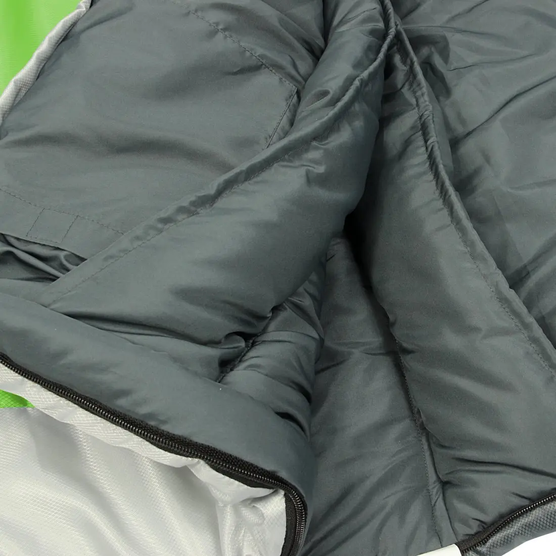 Close-up of the inside lining and zipper of a grey sleeping bag.