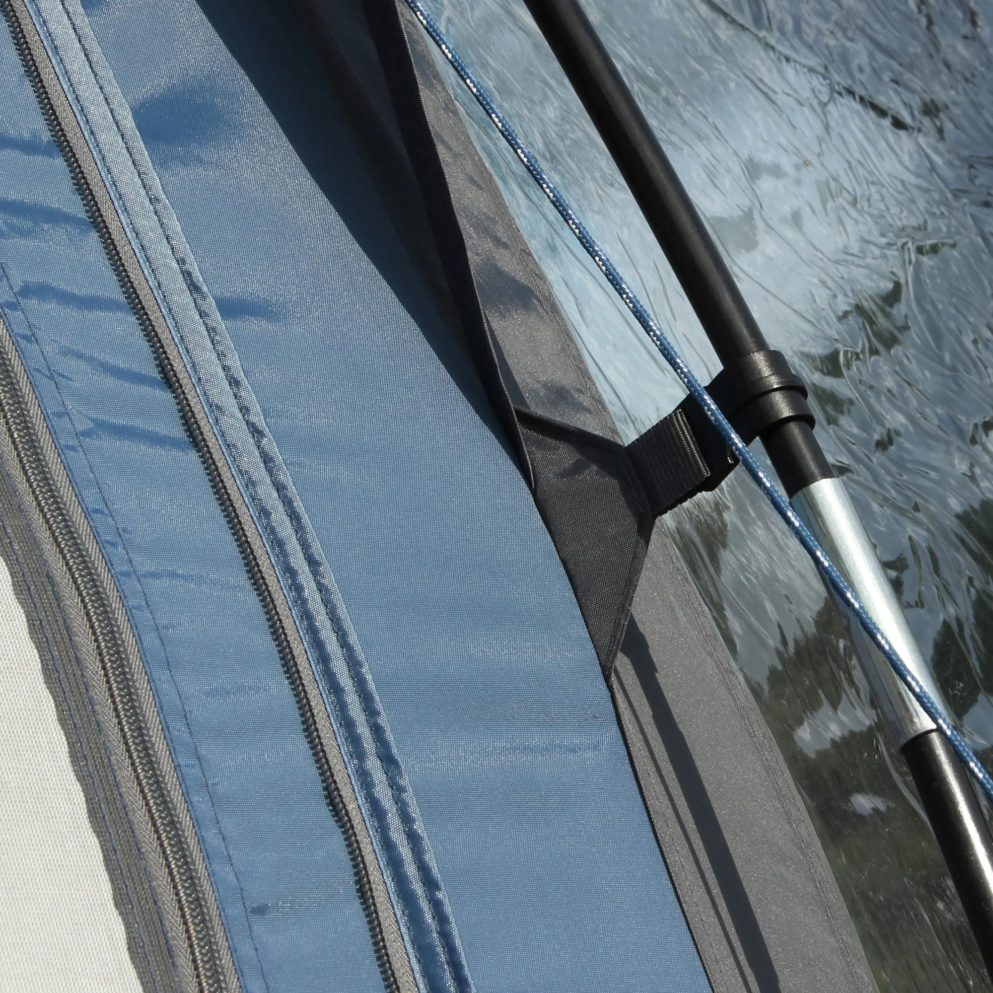 Gros plan sur un détail du auvent de caravane yourGEAR Verona 390, montrant la fermeture éclair robuste, la toile bleue imperméable et la structure de mât solide pour montage facile et étanchéité optimale.