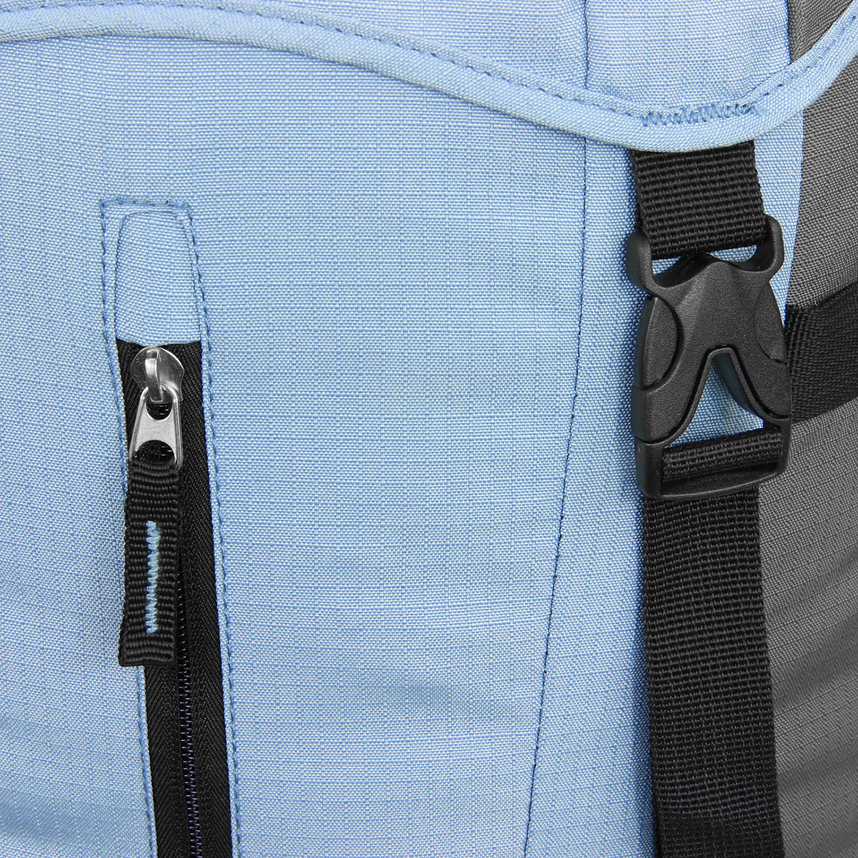 Dettaglio del 10T Rucksack Clarke 45L: primo piano su tessuto blu chiaro, cerniera verticale nera con tiretto e fibbia di plastica nera su cinturino, ideale per trekking e hiking.