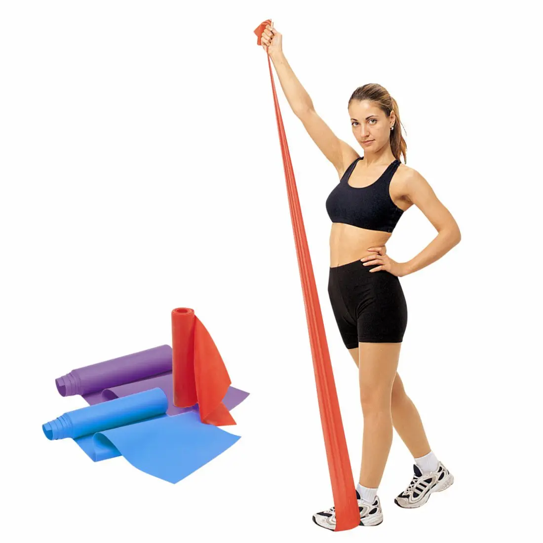 Donna che traina un elastico rosso Carnegie Fitness; accanto, tre fasce da ginnastica in lattice di diversi colori e resistenze (rosso, blu, viola), ideali per allenamento e riabilitazione.