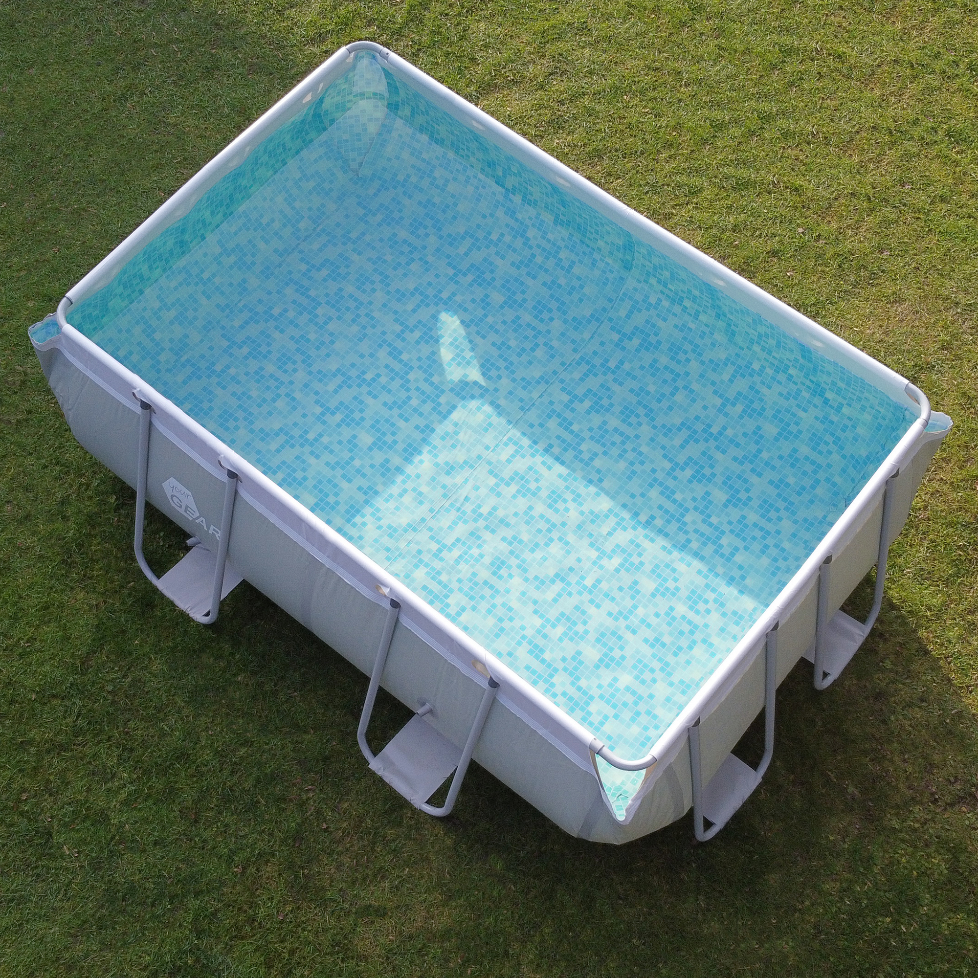 Piscine familiale your GEAR 3x2x1m rectangulaire, cadre en acier, extérieur gris et blanc, intérieur avec motif mosaïque bleu, installée sur une pelouse, idéale pour le jardin ou la terrasse.