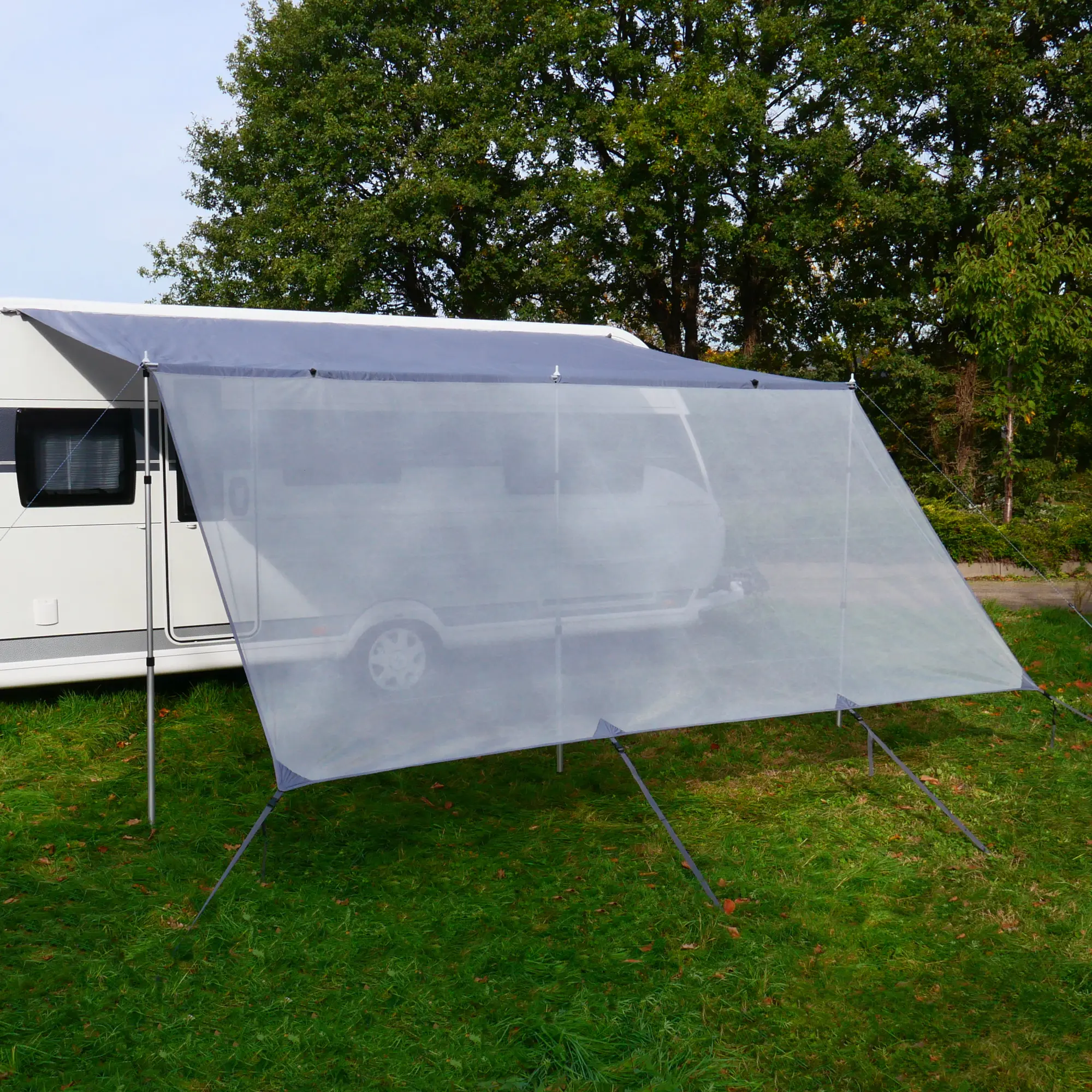 your GEAR Procida 300x200 cm sun protection front wall attached to a caravan canopy, semi-transparent fabric, supported by three poles, providing shade and privacy for camping or outdoor use.