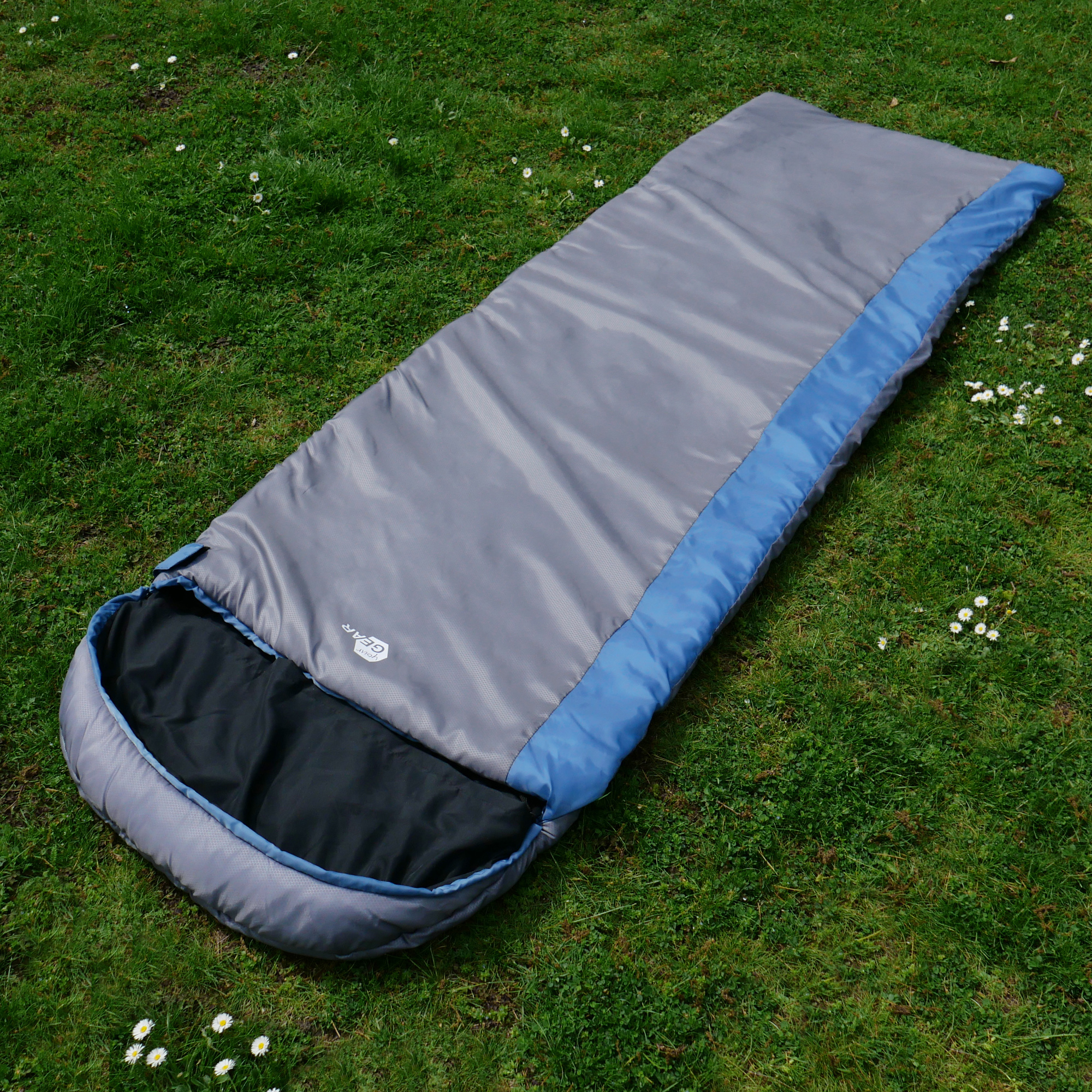 Schlafsack yourGEAR Ostria in Blau-Grau, rechteckige Form, 230x75cm, leichtes Modell für Sommer, auf Wiese ausgebreitet, mit sichtbarem Innenfutter und Logoprint, ideal für Camping und Outdoor.