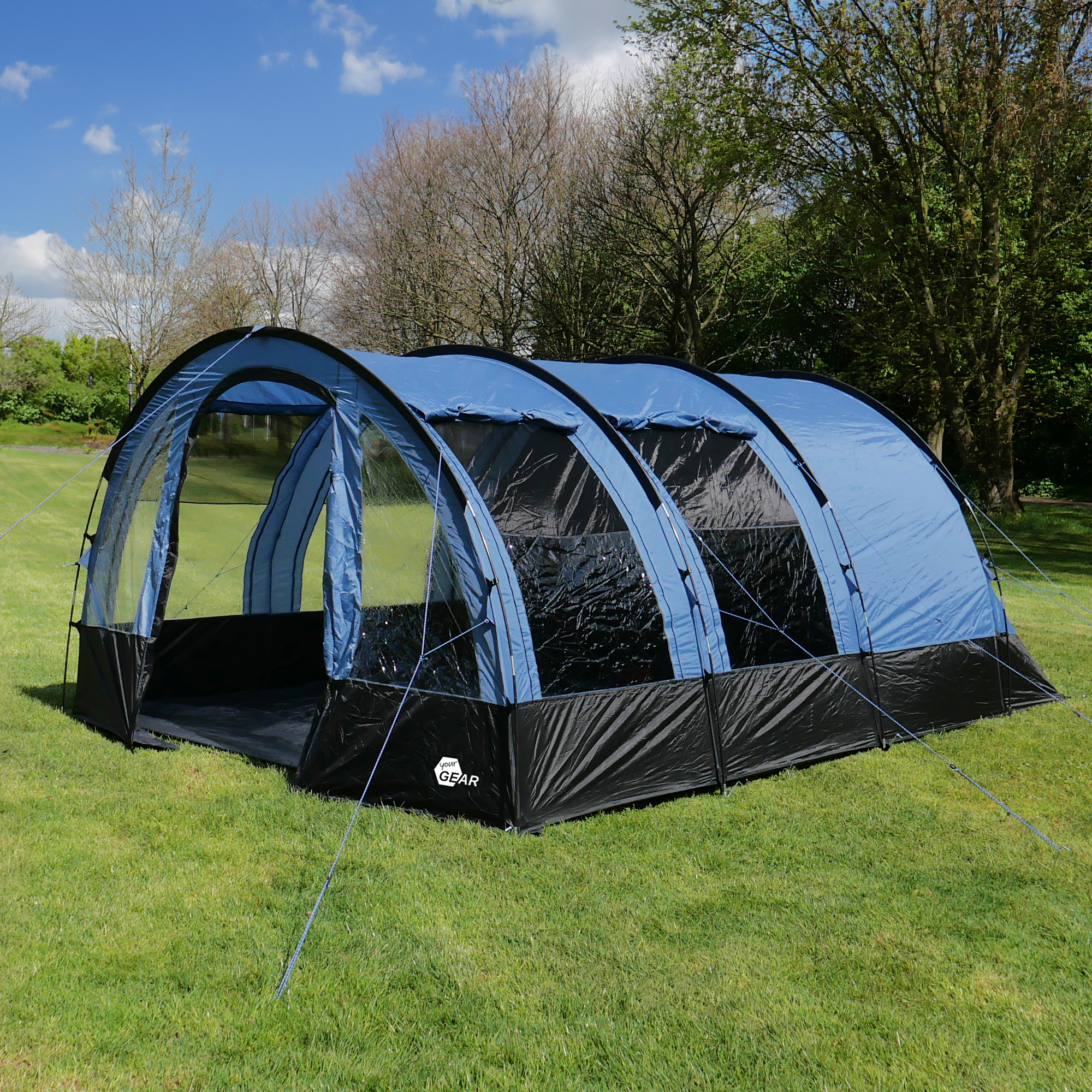 Tente tunnel familiale your GEAR Mistral pour 6 personnes, couleur bleu et noir, avec grandes fenêtres transparentes, structure spacieuse de 490 x 325 x 195 cm, installée sur une pelouse en plein air.