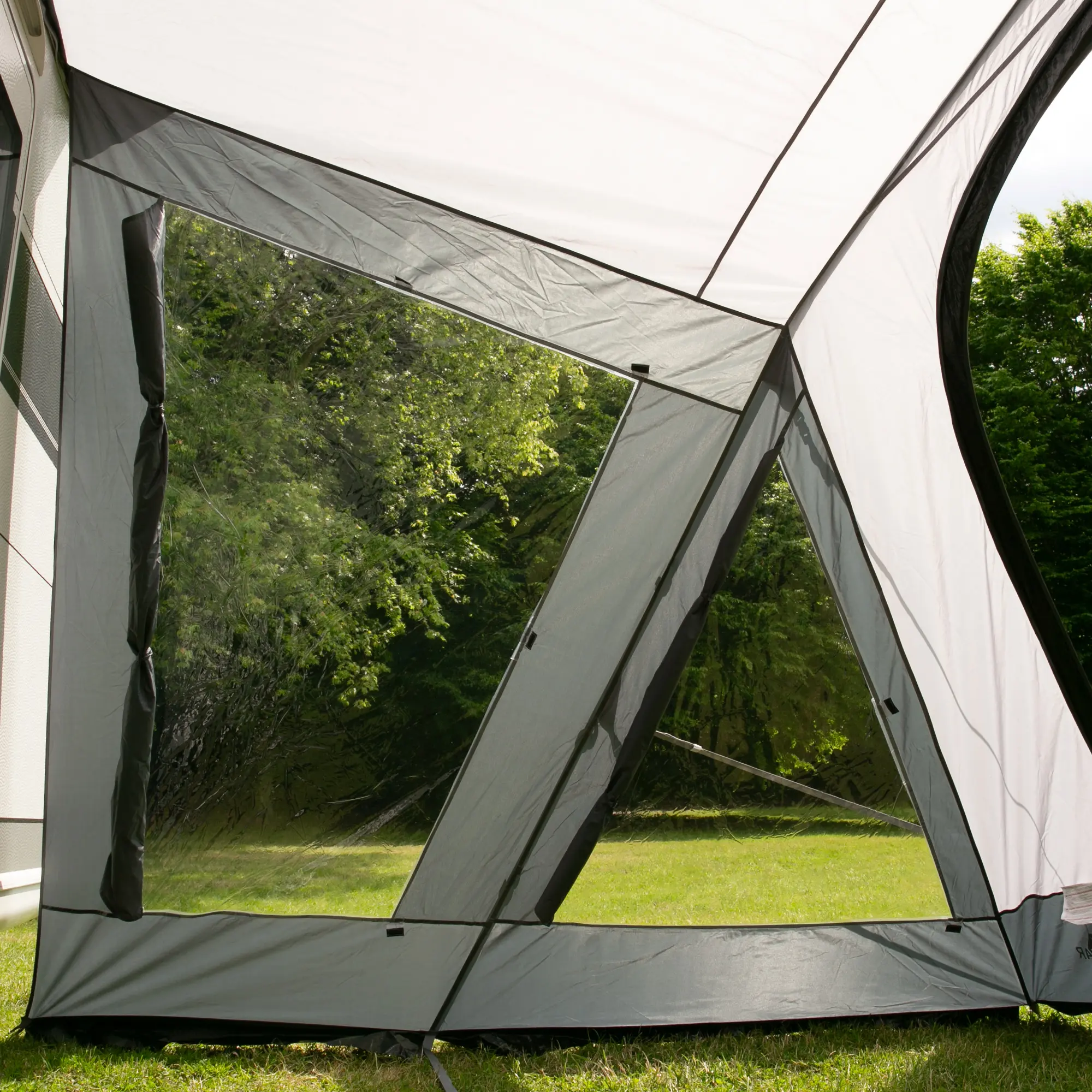 your GEAR Vorzelt Positano 400 mit großen, transparenten Fenstern, robustem 150D Oxford-Gewebe und stabilem Aluminium-Gestänge, aufgestellt am Wohnwagen, Blick ins Grüne. Ideal als Wohnwagenvorzelt.