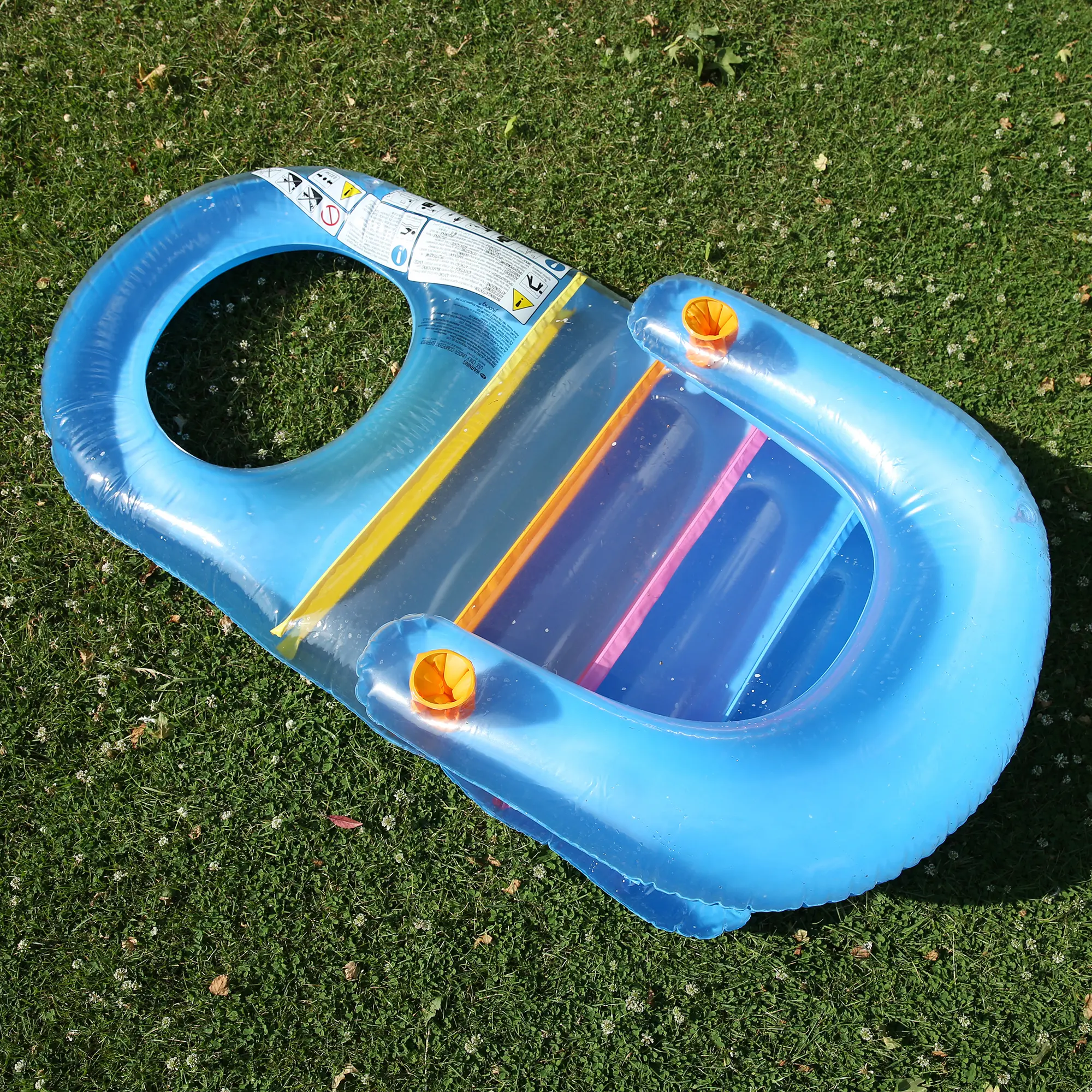 Inflatable Jilong Fashion Lounge Floater, 150x86 cm, blue pool chair with backrest, cup holders, and colorful stripes, designed for relaxing in pools or lakes, shown on green grass.