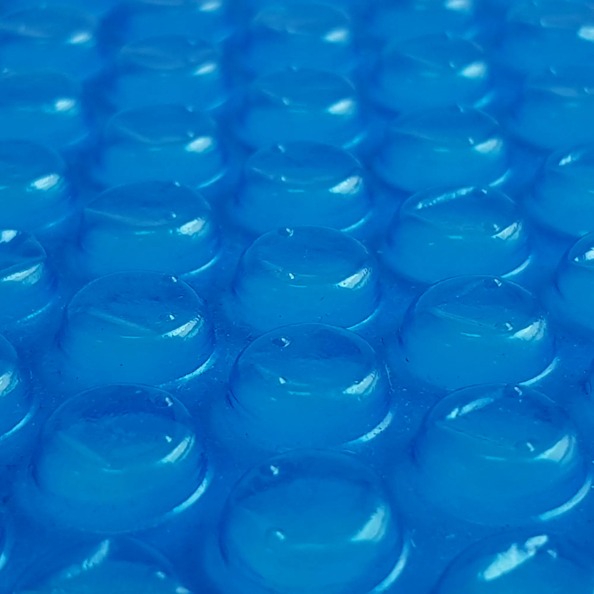 Close-up of your GEAR Solarplane SC-500x800 rectangular pool solar cover, showing blue 300 µm thick bubble solar film texture for solar-powered pool heating and insulation.