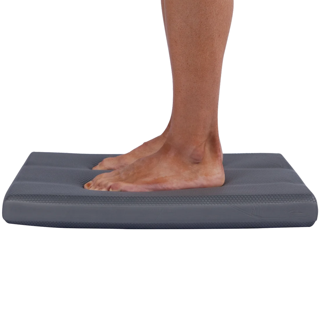 Persona de pie sobre el Spirit Balance-Block XL, cojín de equilibrio gris de 50x40x6 cm, superficie antideslizante y textura visible, ideal para ejercicios de estabilidad y entrenamiento de equilibrio.
